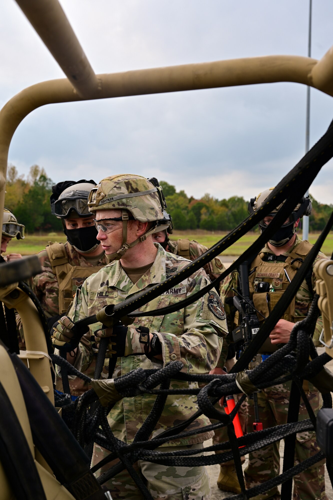 A Soldier inspects the rigging of a support device that attaches an off-road vehicle to a helicopter.