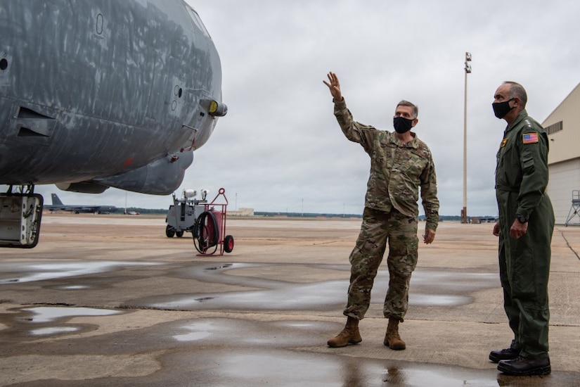 Two military leaders look at a B-52H Stratofortress at a military base.