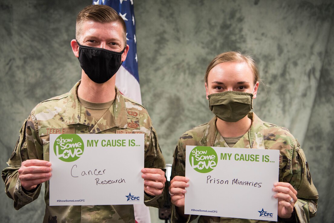 Two Airmen holding CFC Cause signs