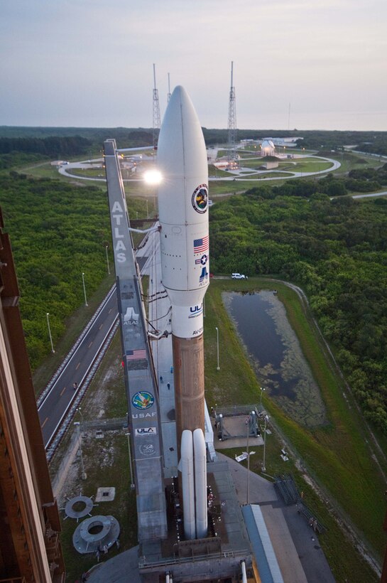 A rocket carrying a satellite payload prepares to launch from a launch pad