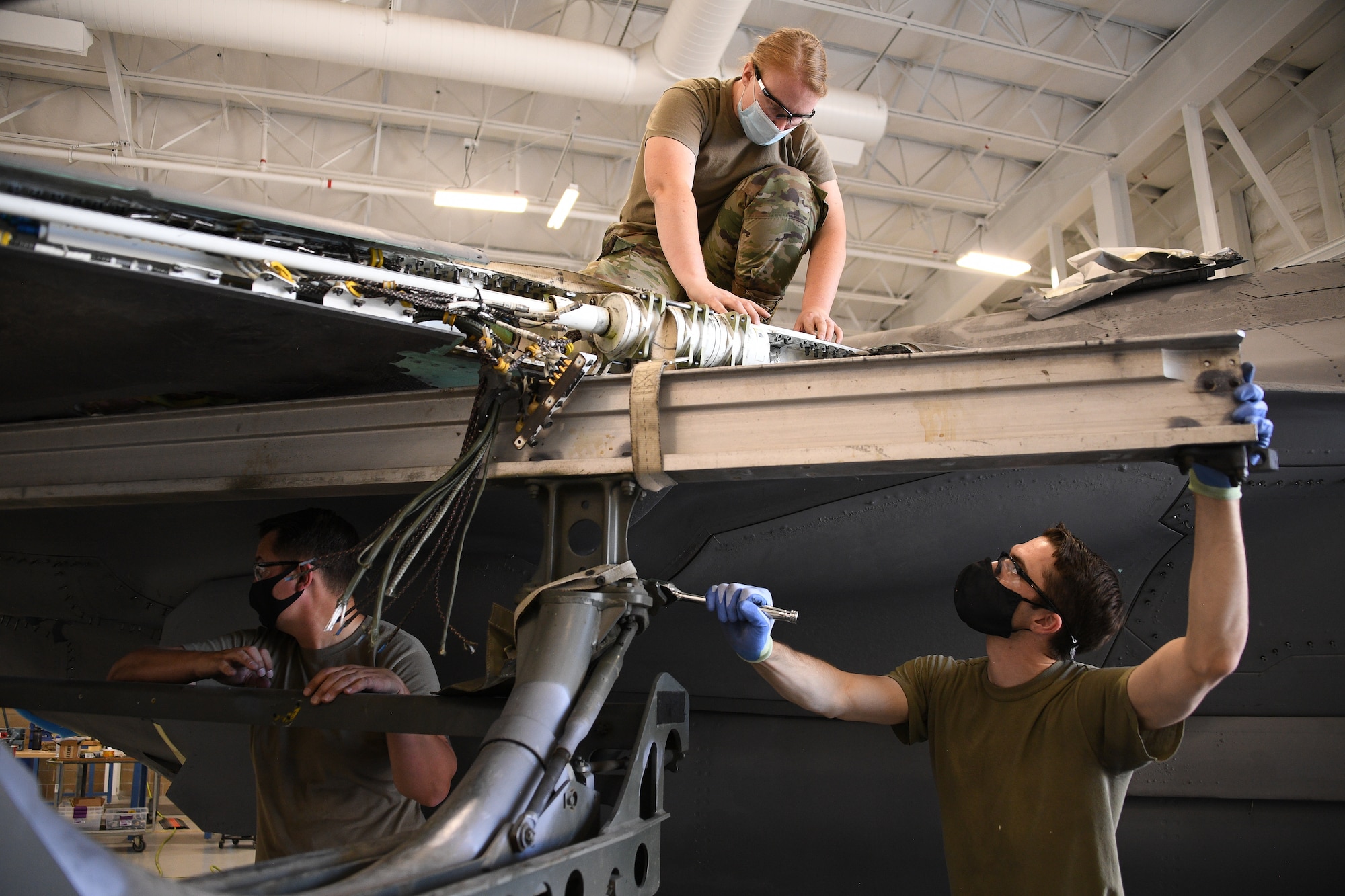 Staff Sgt. Samantha Birnshein and Tech. Sgt. Emil Wodicka, 372nd Training Squadron Detachment 3, work a wing reattachment and repair on a repurposed F-35A Lightning II.