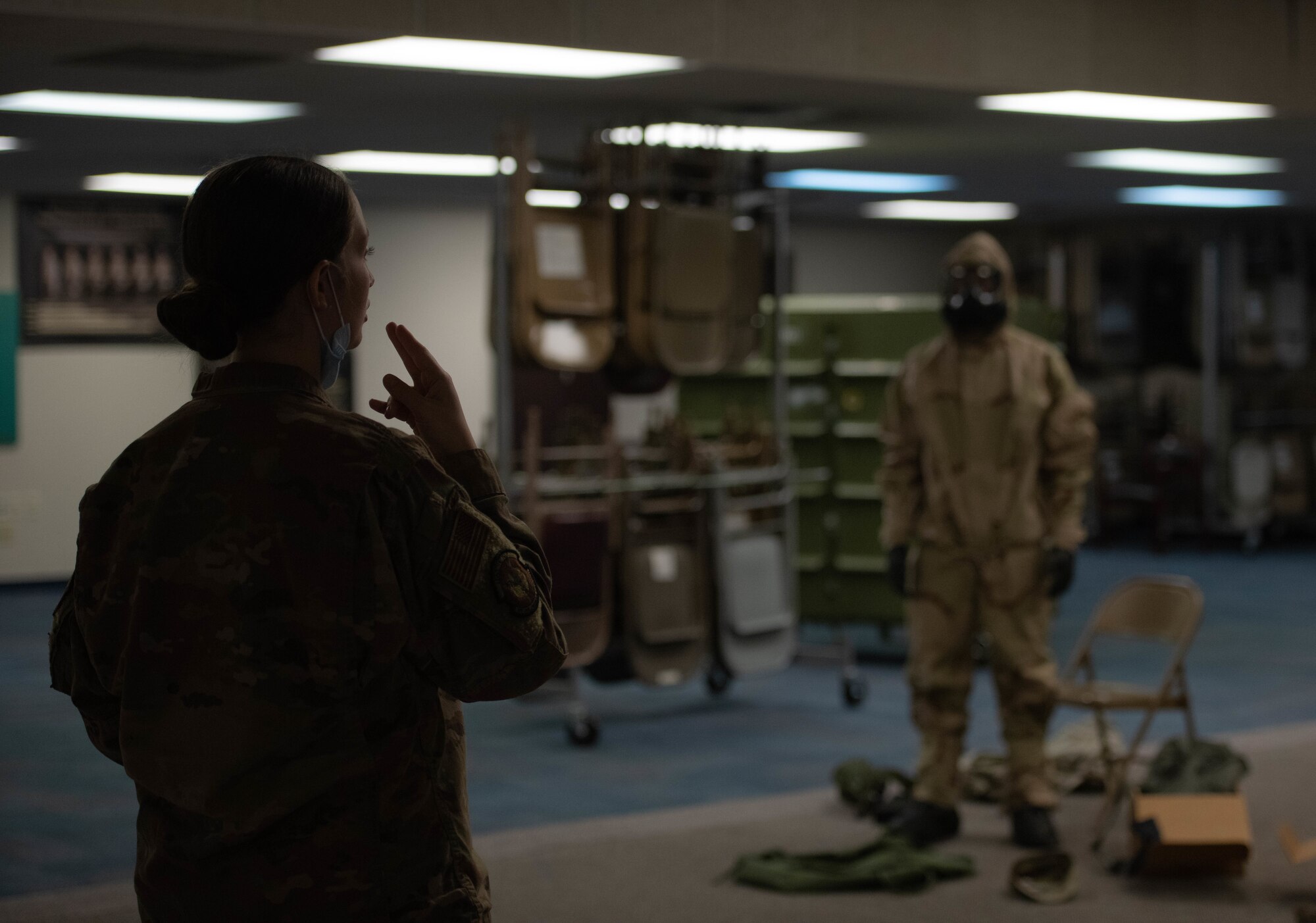 Airman instructs student in MOPP gear.