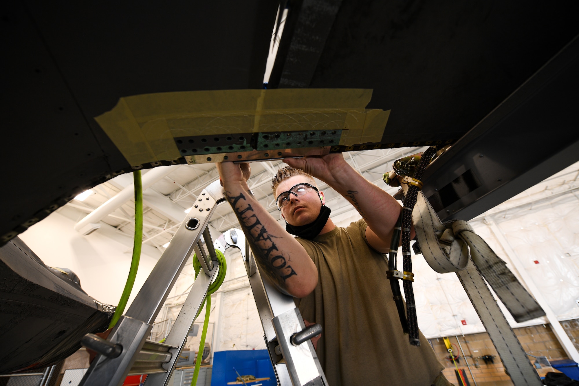 Staff. Sgt. Jesse Thompson, 309th Expeditionary Depot Maintenance, works a wing reattachment and repair on a repurposed F-35A Lightning II.