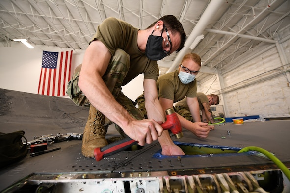 Tech. Sgt. Emil Wodicka, left, and Staff Sgt. Samantha Birnschein, 372nd Training Squadron Detachment 3, work a wing reattachment and repair on a repurposed F-35A Lightning II.
