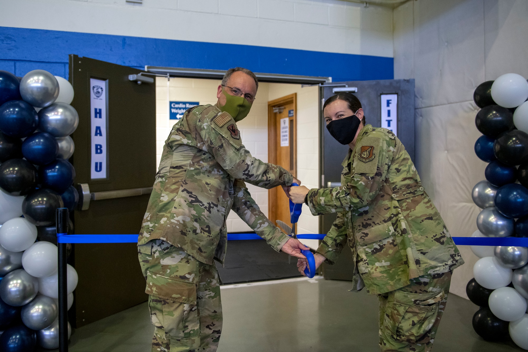 U.S. Air Force Col. George Vogel, 18th Wing vice commander and Lt. Col. Jama Stilwell, 718th Force Support Squadron commander, cut the ribbon during the Habu Fitness Center grand opening ceremony at Kadena Air Base, Japan, Oct. 22, 2020. The facility will be open Monday – Friday, from 6 a.m. to 10 p.m., and closed on weekends, holidays and family days. (U.S. Air Force photo by Naoto Anazawa)