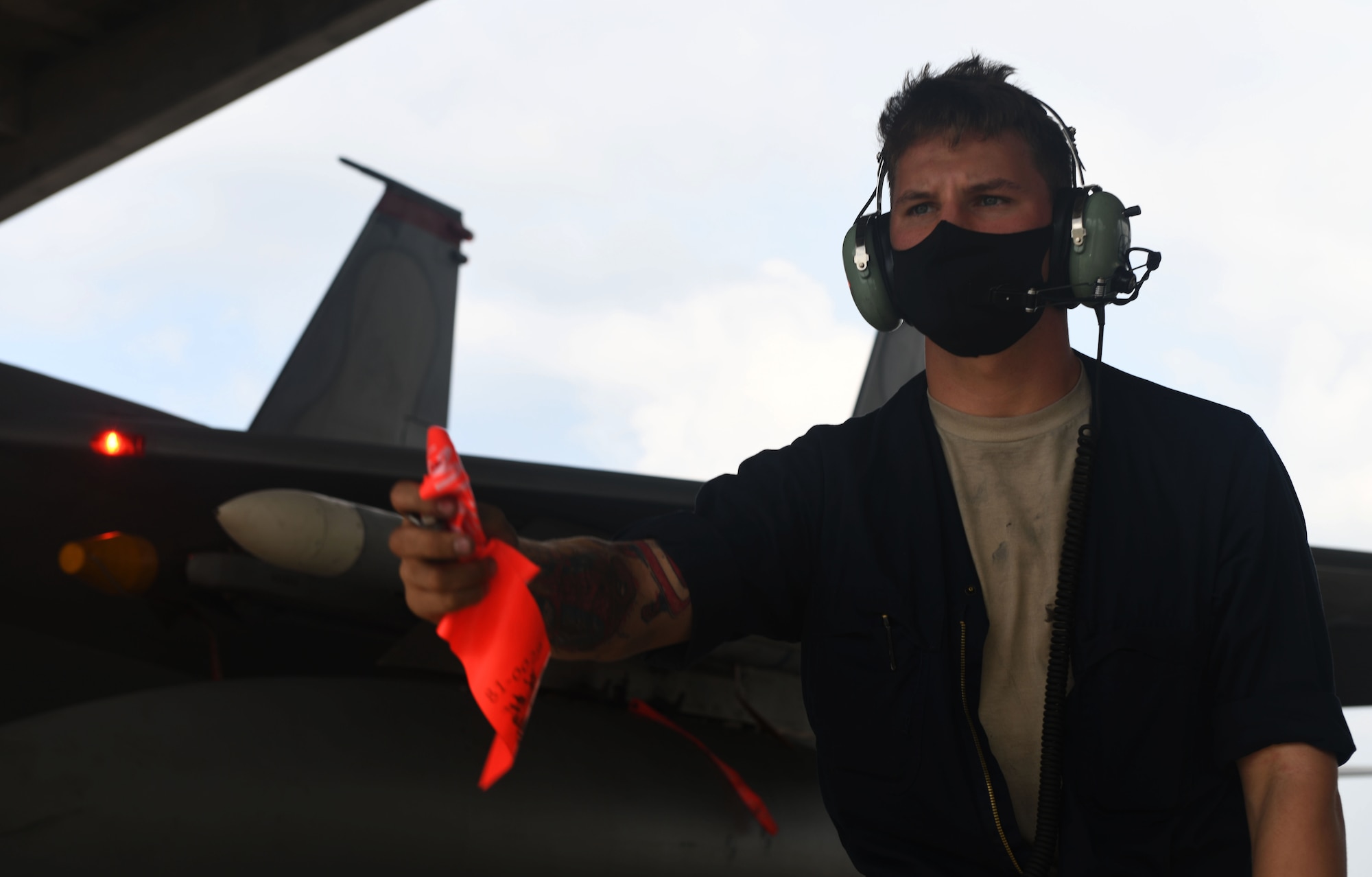 U.S Air Force Senior Airman Ryan Takacs, 18th Aircraft Maintenance Squadron crew chief, removes a flag from an F-15C Eagle during Exercise WestPac Rumrunner Oct. 16, 2020, at Kadena Air Base, Japan. The National Defense Strategy directs the armed forces to be more lethal, enhance relationships with allies and partners, and encourage institutional reform. The 18th Wing is employing this directive by developing and continuing new training exercises like WestPac Rumrunner. This exercise represents an evolution in training to adapt to the environment of great power competition. (U.S. Air Force photo by Tech. Sgt. Benjamin Sutton)