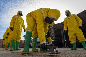 Photo of an Airman scanning the ground for contamination during a training exercise