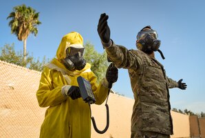Photo of an Airman scanning another Airman for contamination