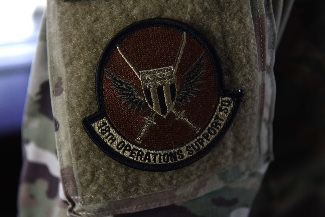 An Airman from the 18th Operations Support Squadron wears an 18th OSS patch during Exercise WestPac Rumrunner at Kadena Air Base, Japan, Oct. 16, 2020. The day-long exercise hailed several aircraft to include P-8s, F-16s and C-130Js; some coming all the way from Yokota and Misawa, as well as many home station aircraft – providing a number of training opportunities from the planning to the completion of the exercise. Kadena’s air traffic control tower utilizes training and experience in order to create an efficient and safe environment for the aircraft to depart and recover. (U.S. Air Force photo by Staff Sgt. Kristan Campbell)