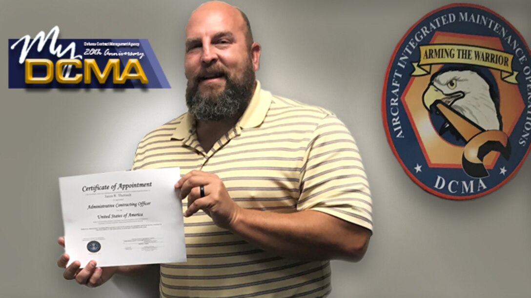 Man wearing a yellow-striped shirt holds a certificate