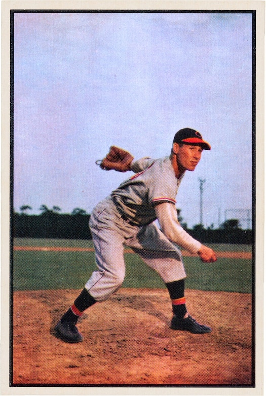 A baseball player pitches a ball.
