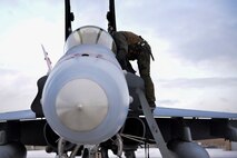 A U.S. Marine Corps F/A-18 Hornet pilot assigned to the Marine Fighter Attack Squadron (VMFA) 232 climbs into his aircraft at Eielson Air Force Base, Alaska, Oct. 20, 2020.