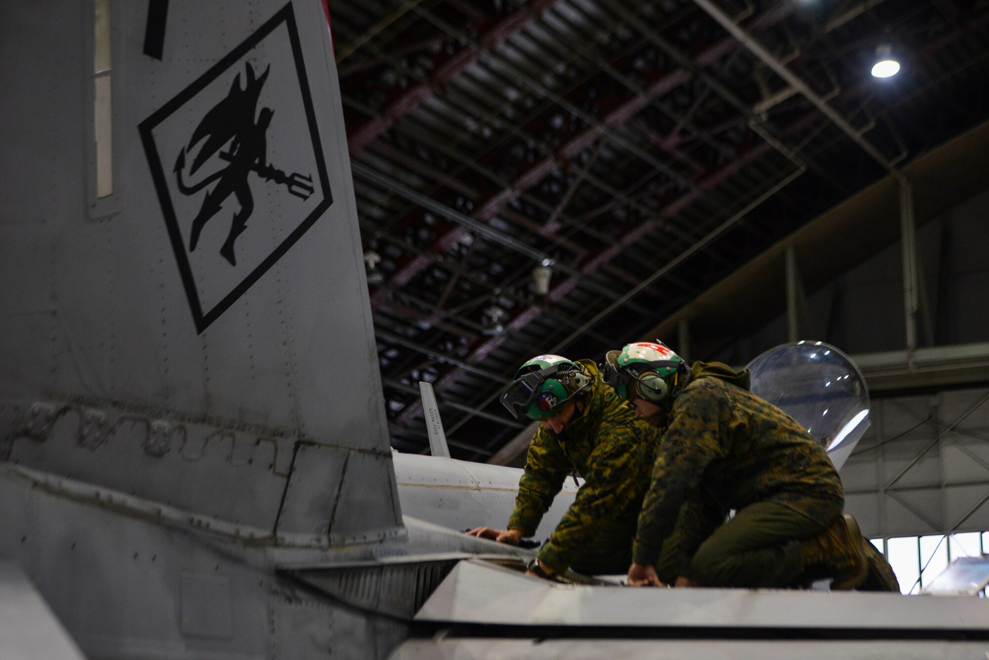 U.S. Marine Corps Gunnery Sgt. Jason C. Alvarez, Sr. (left), the Marine Fighter Attack Squadron (VMFA) 232 airframes division chief, and Pfc. Michael A. Flores, a VMFA-232 airframes mechanic, install a trailing edge flap servo on an F/A-18 Hornet during RED FLAG-Alaska (RF-A) 21-1 at Eielson Air Force Base, Alaska, Oct. 21, 2020.