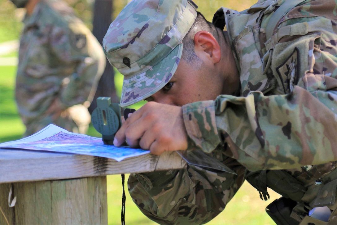 A soldier looks through a compass.