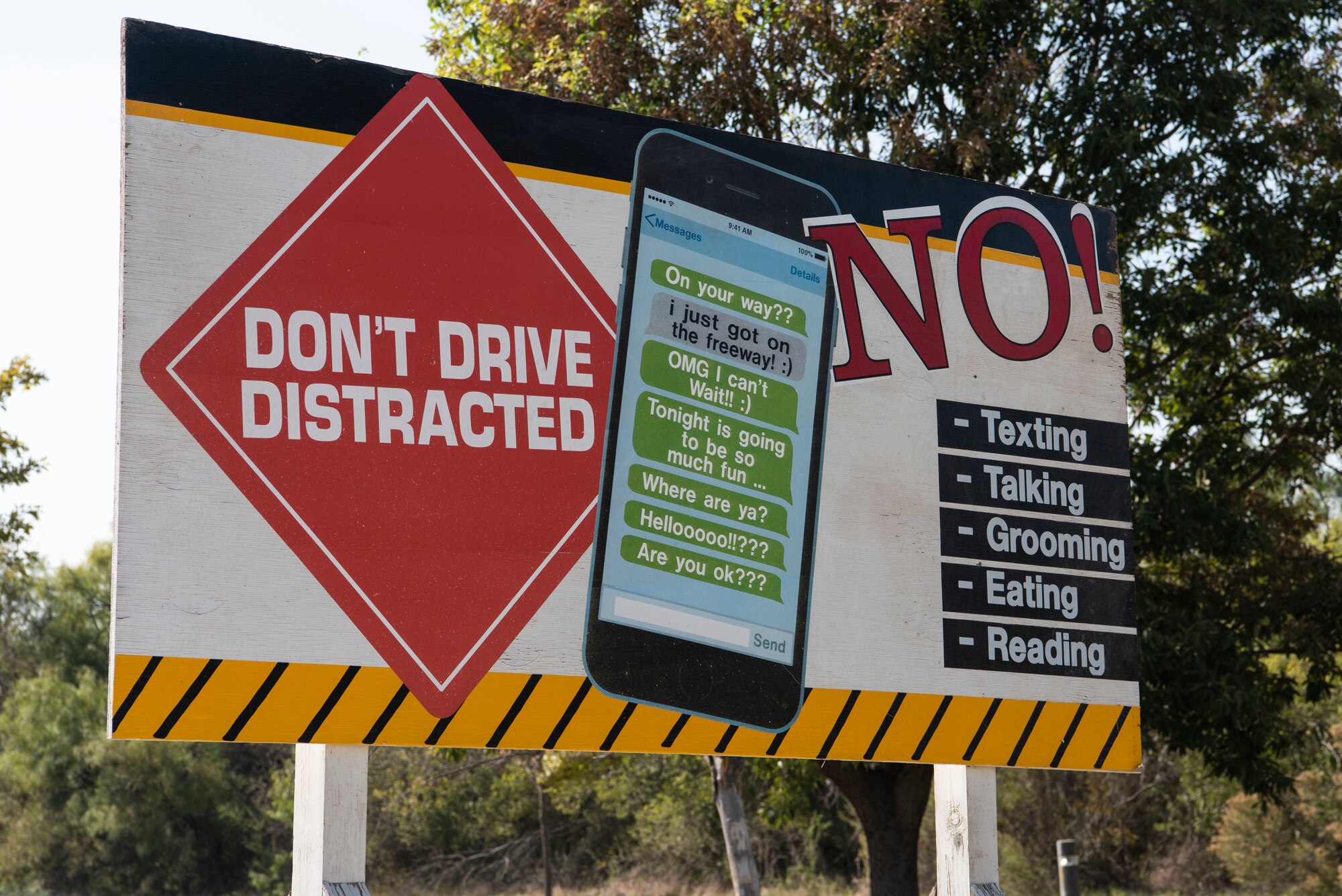 A sign stands to remind base personnel and their families to put away phones while driving and focus their full attention on the road while driving at Laughlin Air Force Base, Texas, Oct. 14, 2020. “Although everyone is at risk, whether you’re the distracted driver or you get hit by the distracted driver, the youth are the most at-risk demographic,” said Alexander Valdez, 47th Flying Training Wing Occupational Safety Specialist. “But we are all responsible for putting our phones down for a couple of minutes while we drive.” (U.S. Air Force photo by Senior Airman Marco A. Gomez)