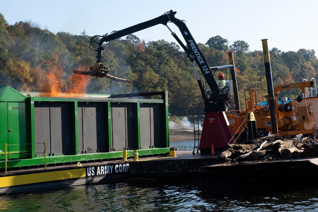 Lead Operator Jesse Neal operates the grapple crane on the PRIDE of the Cumberland, placing debris into an air curtain burner on a new floating barge Oct. 21, 2020 in Lake Cumberland near Waitsboro Recreation Area in Somerset, Kentucky. (USACE Photo by Lee Roberts)