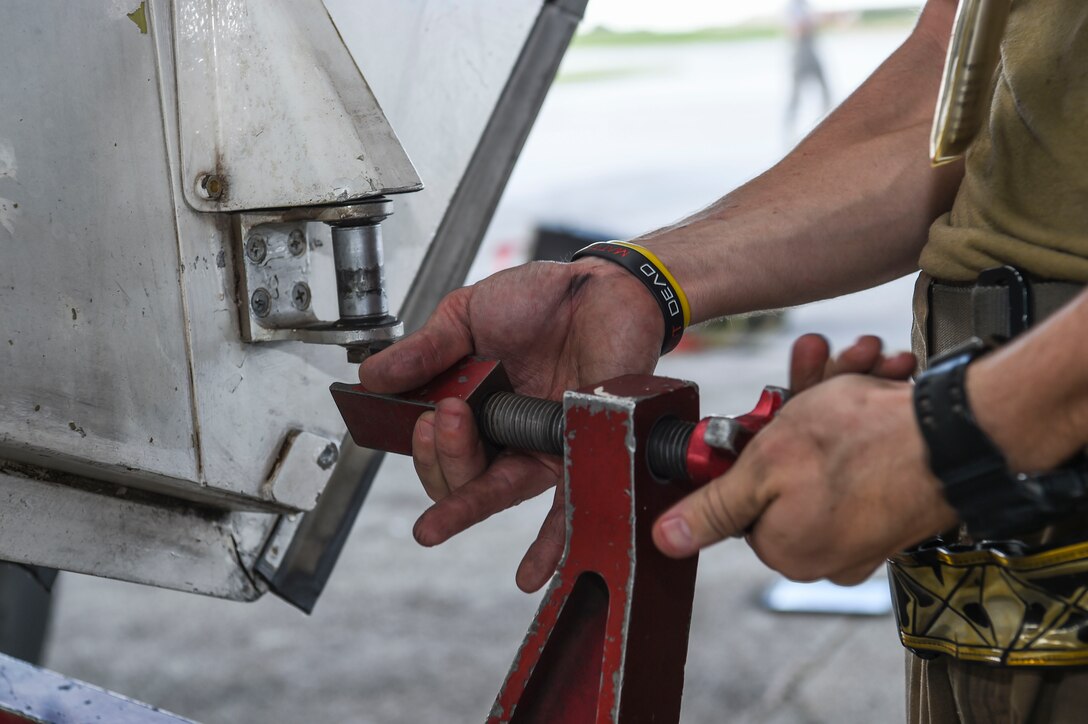 Senior Airman Andrew Burris, 9th Expeditionary Bomb Squadron crew chief, tightens a B-1B Lancer aircraft main landing gear, during a Bomber Task Force deployment, at Andersen Air Force Base, Guam, Oct. 20, 2020.