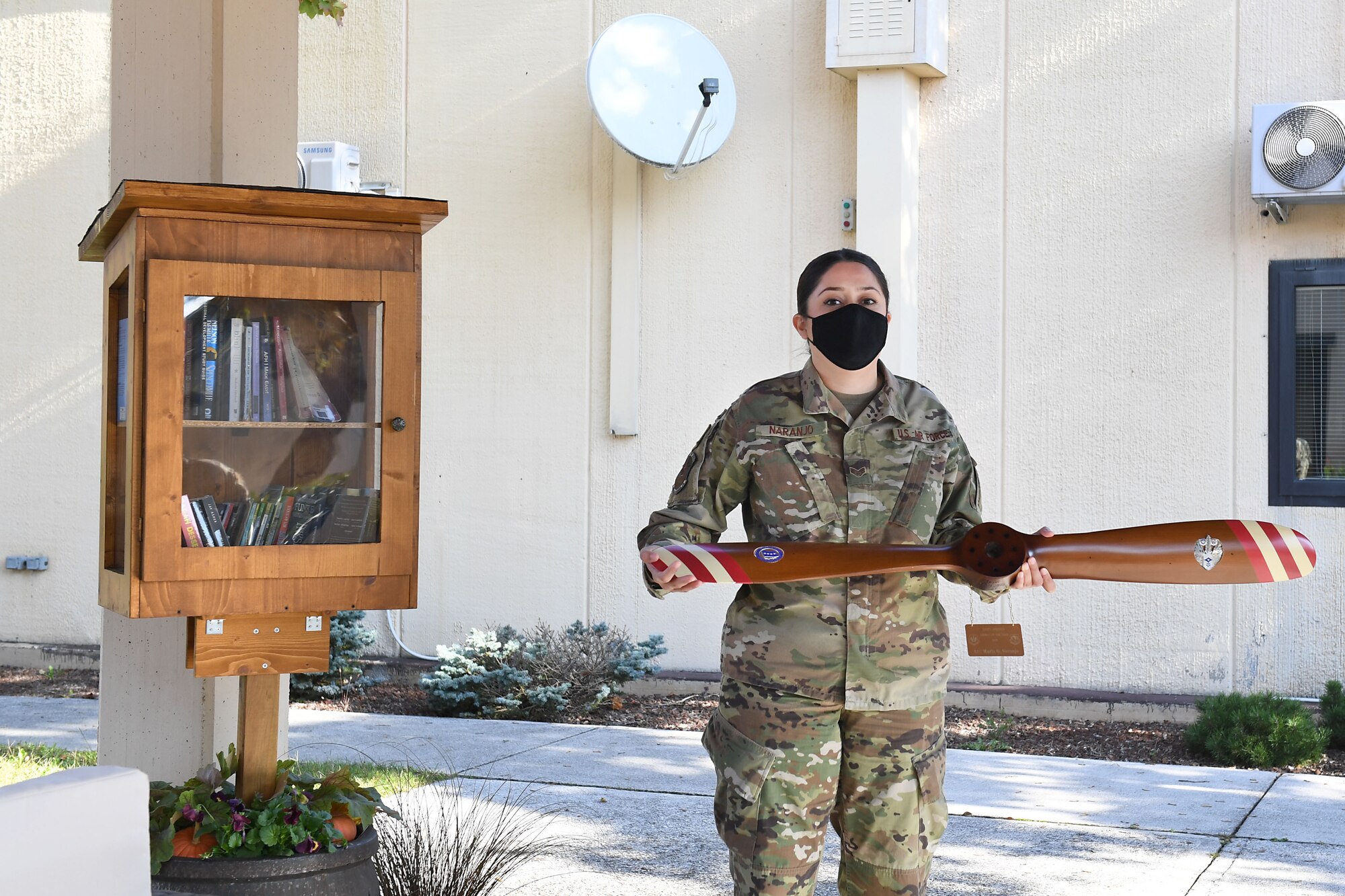 Senior Airman Maria Naranjo, 606th Air Control Squadron cyber transport systems technician, poses with her award for the 2019 U.S. Air Forces in Europe and Air Forces Africa Airman of the Year at Aviano Air Base, Italy, Oct. 14, 2020. During her time at Aviano, Naranjo began a squadron book club in an effort to boost morale during the onset of COVID-19 and led an animal shelter volunteer team which secured foster homes for 25 animals in need.