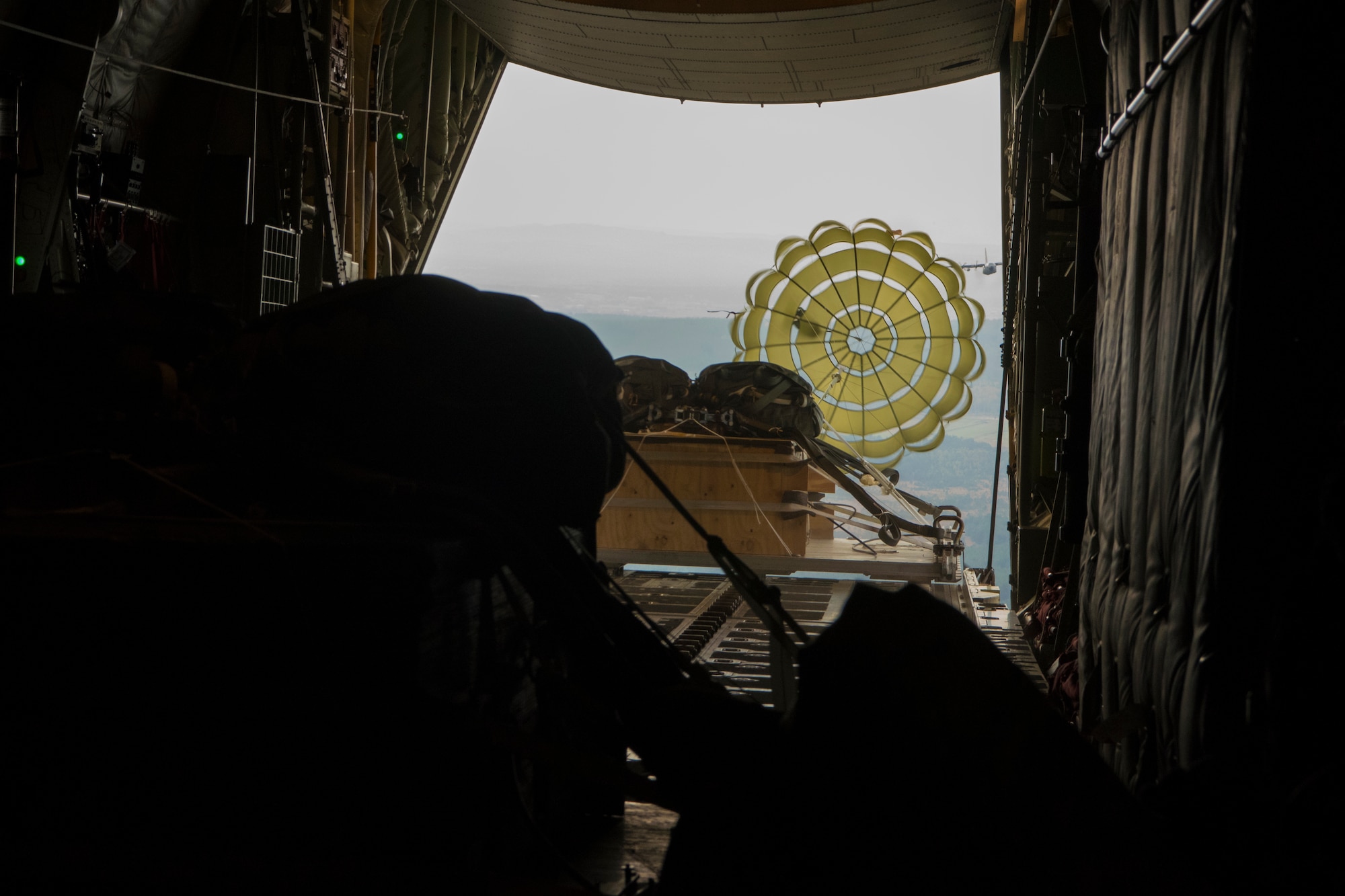 Photo of a crate parachuting from a U.S. Air Force C-130J Super Hercules