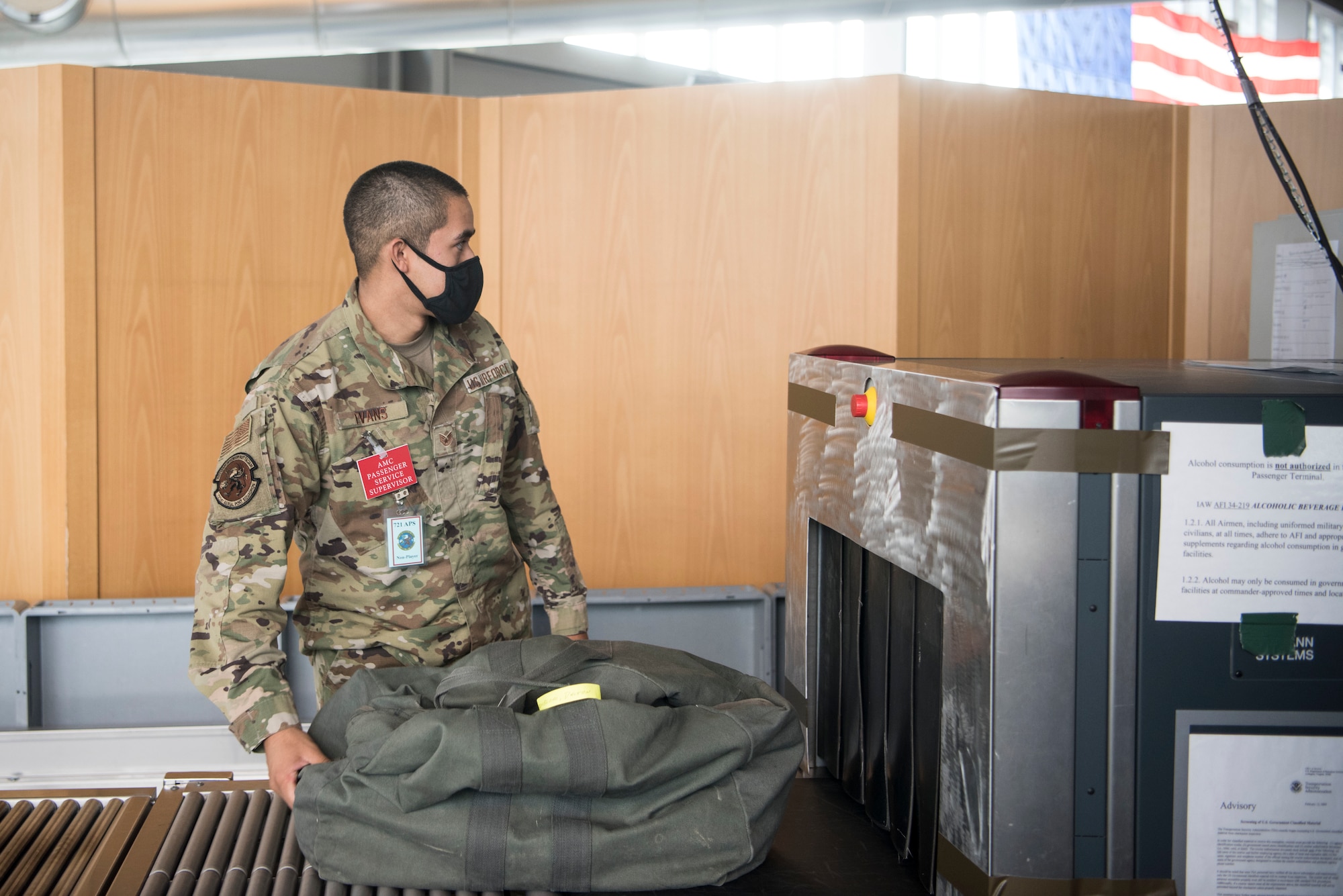 U.S. Air Force Staff Sgt. Sean Evans, 721st Aerial Port Squadron passenger service supervisor, prepares to push a bag into a security scanner during exercise Nodal Lightning 20-2