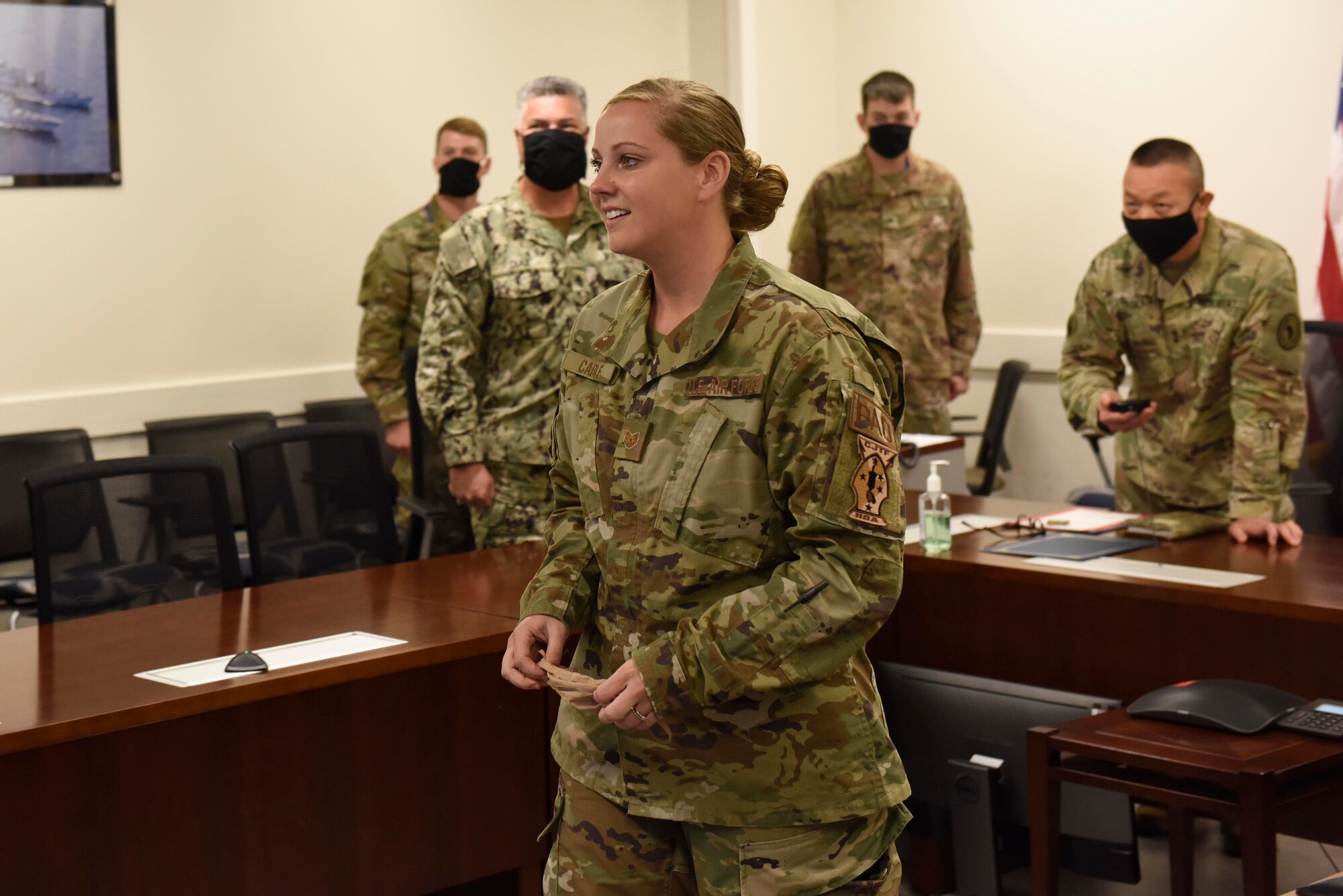 U.S. Air Force Tech. Sgt. Dana Cable stands facing the  Video Teleconference Center