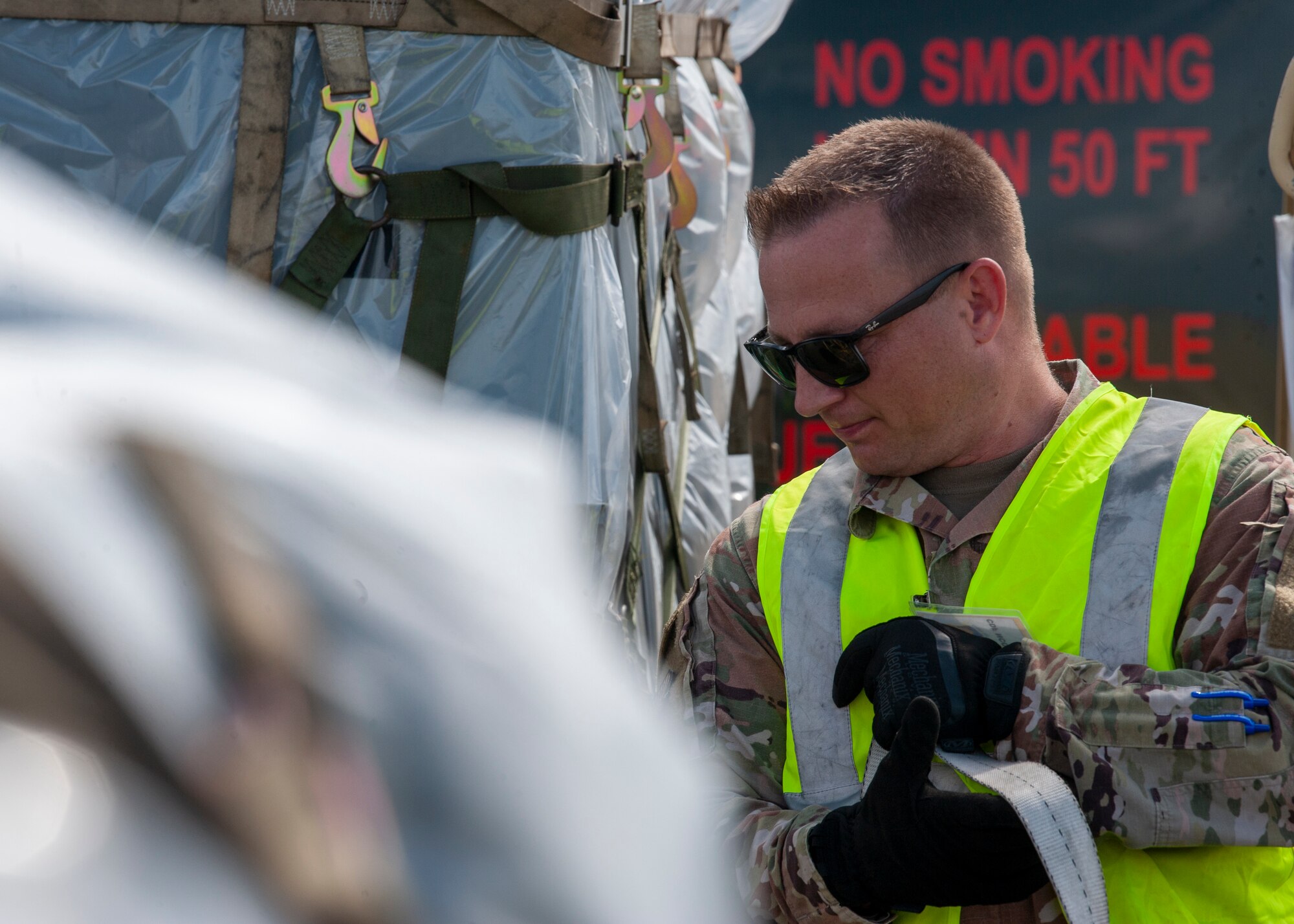 U.S. Air Force Master Sgt. Michael A. Smith, the 6th Logistics Readiness Squadron cargo deployment function NCO in charge, holds onto a pallet strap on the flightline, Oct. 21, 2020 at MacDill Air Force Base, Fla. The orientation of the pallet when it is loaded determines where the straps go, to prevent items from sliding around during transportation. (U.S. Air Force Photo by A1C David D. McLoney)