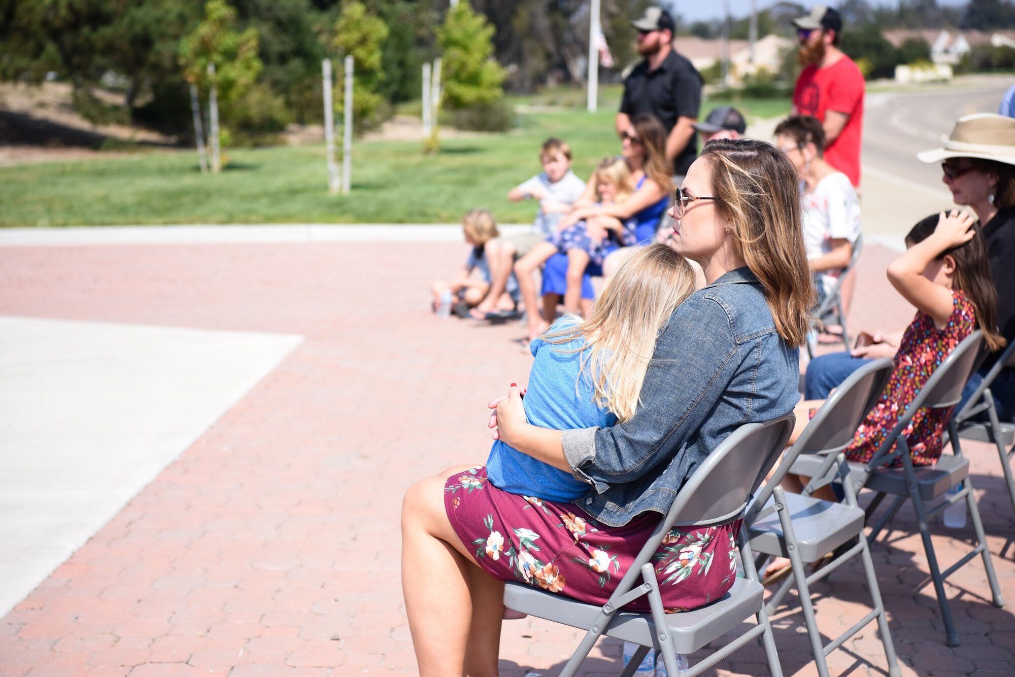 Kristen Johnson and her family sit during the 10 year anniversary wreath laying ceremony honoring the life of her late husband, Senior Airman Daniel Johnson, Oct. 4, 2020, at Vandenberg Air Force Base, Calif. Johnson was a 30th Civil Engineer Squadron Explosive Ordinance Disposal Airman assigned to Vandenberg AFB who was killed on duty during a deployment to Kandahar Airfield, Afghanistan, in support of Operation Locating Bravo in 2010. (U.S. Space Force photo by Senior Airman Hanah Abercrombie)