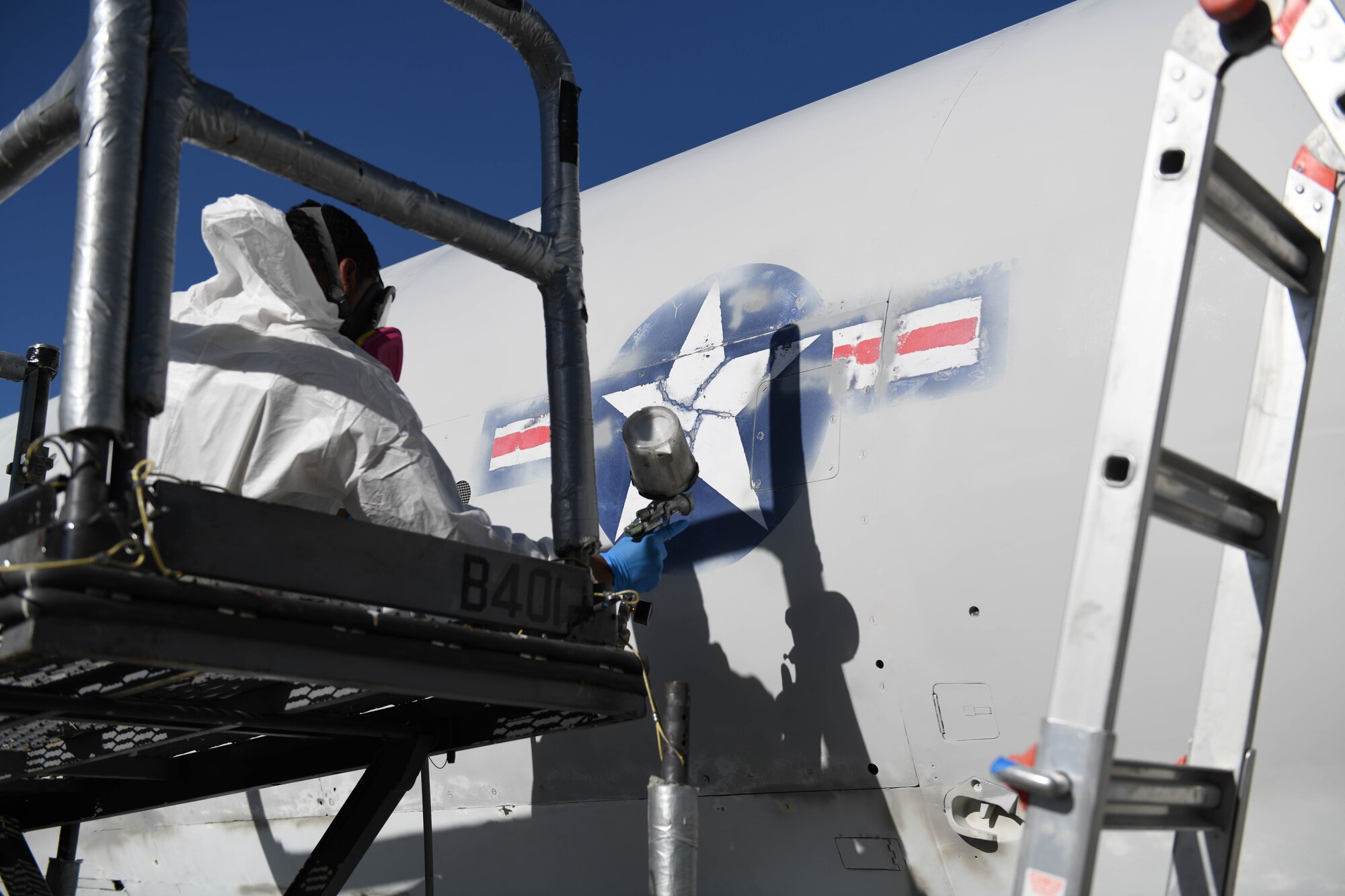 U.S. Air Force Airman 1st Class Tracy Bethea, 509th Maintenance Squadron low-observable maintenance technician, paints around the Air Force Roundel at Whiteman Air Force Base, Missouri, Oct. 13, 2020. The body of the Boeing B-47 Stratojet static aircraft had to be sanded down during restoration before any painting could begin. (U.S. Air Force photograph by Airman 1st Class Devan Halstead)