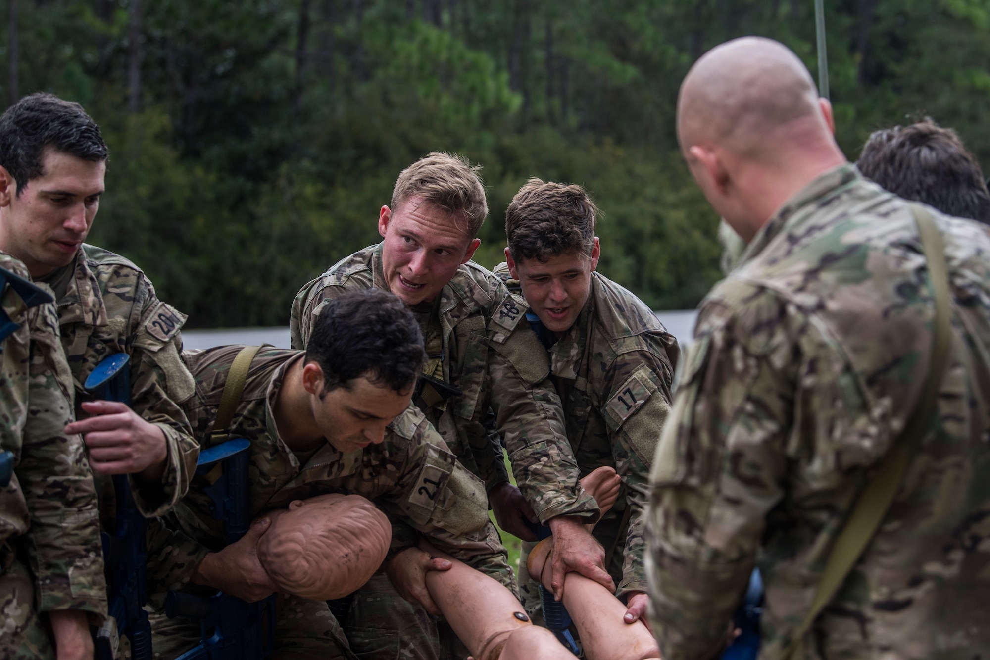 Special Tactics tactical air control party candidates discuss options while they carry a mannequin between them.