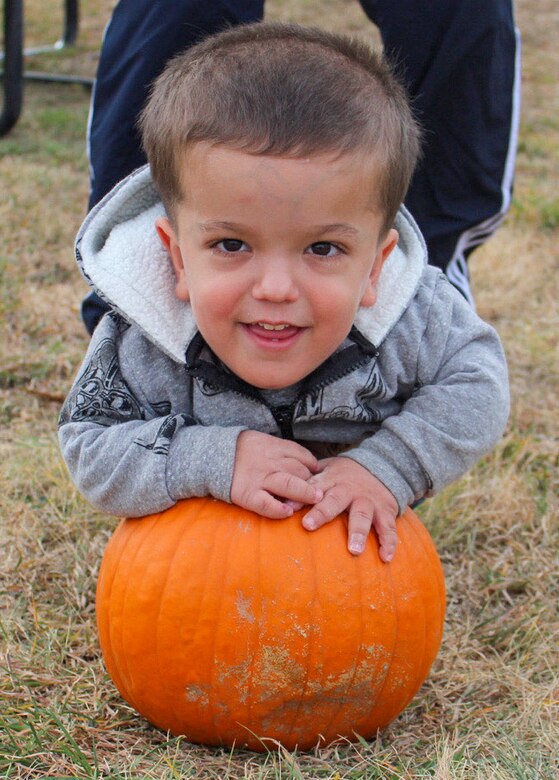 Osiris, 3, smiles as he helps members of the Child Development Center put pumpkins in a container Oct. 20, 2020, in preparation for the pumpkin carving contest  at Schriever Air Force Base, Colorado. The pumpkins are for the 50th Force Support Squadron’s pumpkin carving contest, which must be dropped off at the Schriever Event Center by Oct. 29. (U.S. Space Force photo by Marcus Hill)
