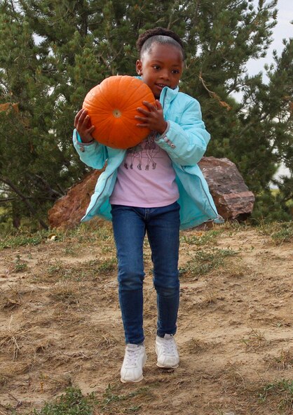 Naomi, 5, walks downhill as she returns a pumpkin to its location Oct. 20, 2020, at Schriever Air Force Base, Colorado. Pumpkins delivered to the Child Development Center for the pumpkin carving contest Oct. 29 will be displayed during the 50th Force Support Squadron’s Jack-O’-Lantern Jubilee Oct. 30 following the pumpkin carving contest. (U.S. Space Force photo by Marcus Hill)