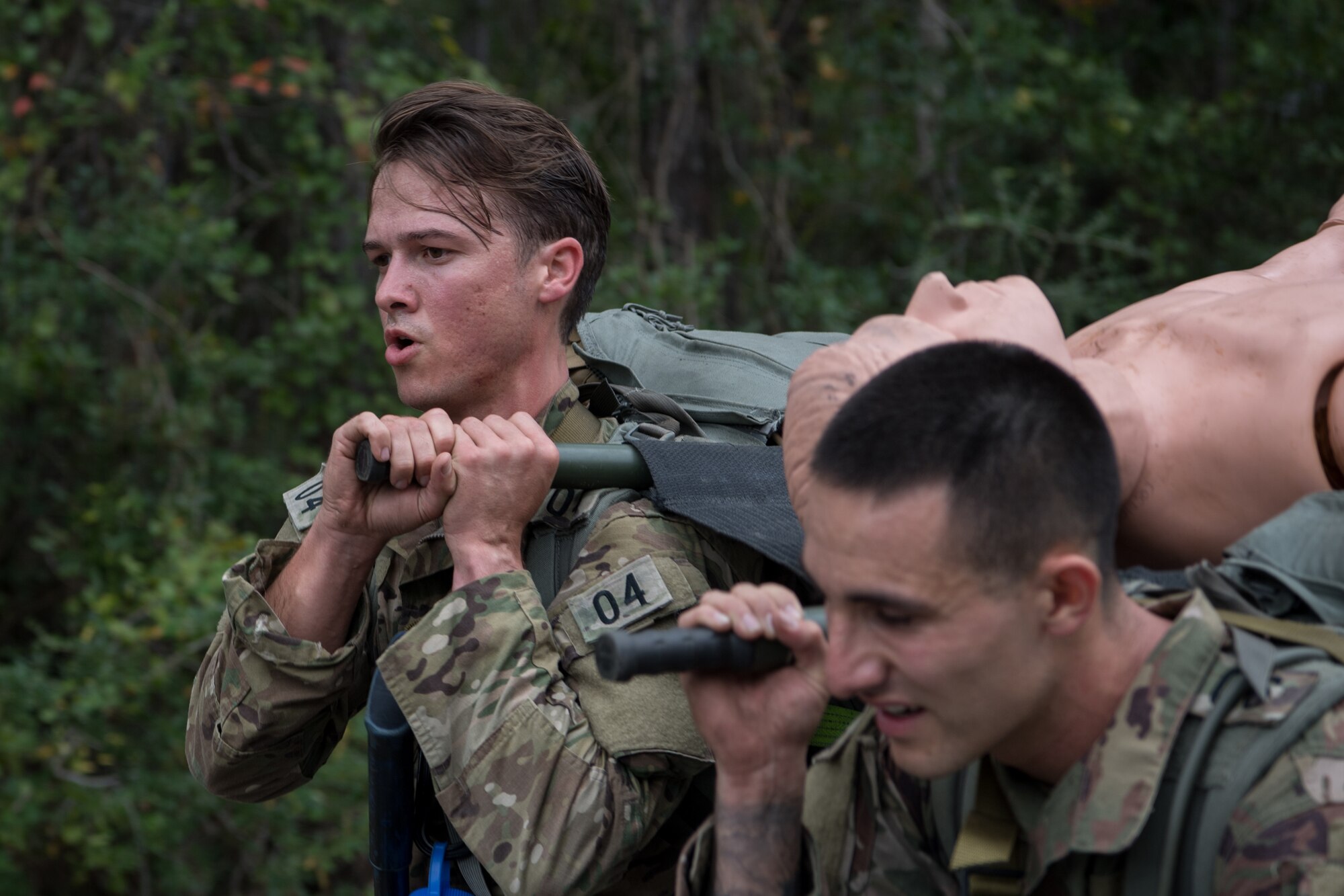 Two Special Tactics tactical air control party candidates carry a litter with a simulated patient during assessment