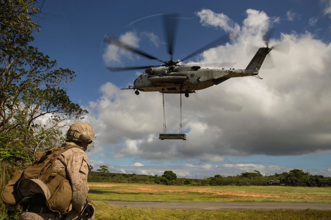 A Marine watches a helicopter takeoff.