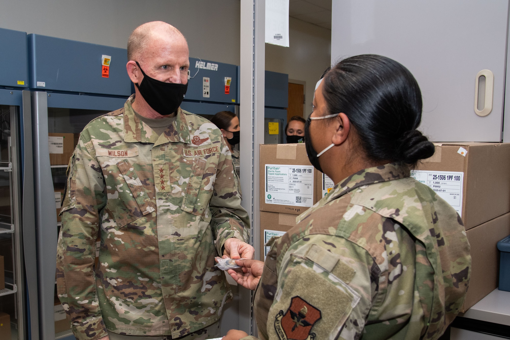 Vice Chief of Staff of the Air Force Gen. Stephen W. Wilson presents a decorative coin to Master Sgt. Simone Moonsammy-Robinson to show appreciation for her contribution to the COVID-19 response during a visit to the 42nd Medical Group, Oct. 22, 2020, Maxwell Air Force Base, Alabama. Moonsammy-Robinson developed a plan to make the packaging and shipment of COVID-19 tests more efficient and standardized. (U.S. Air Force photo by William Birchfield)