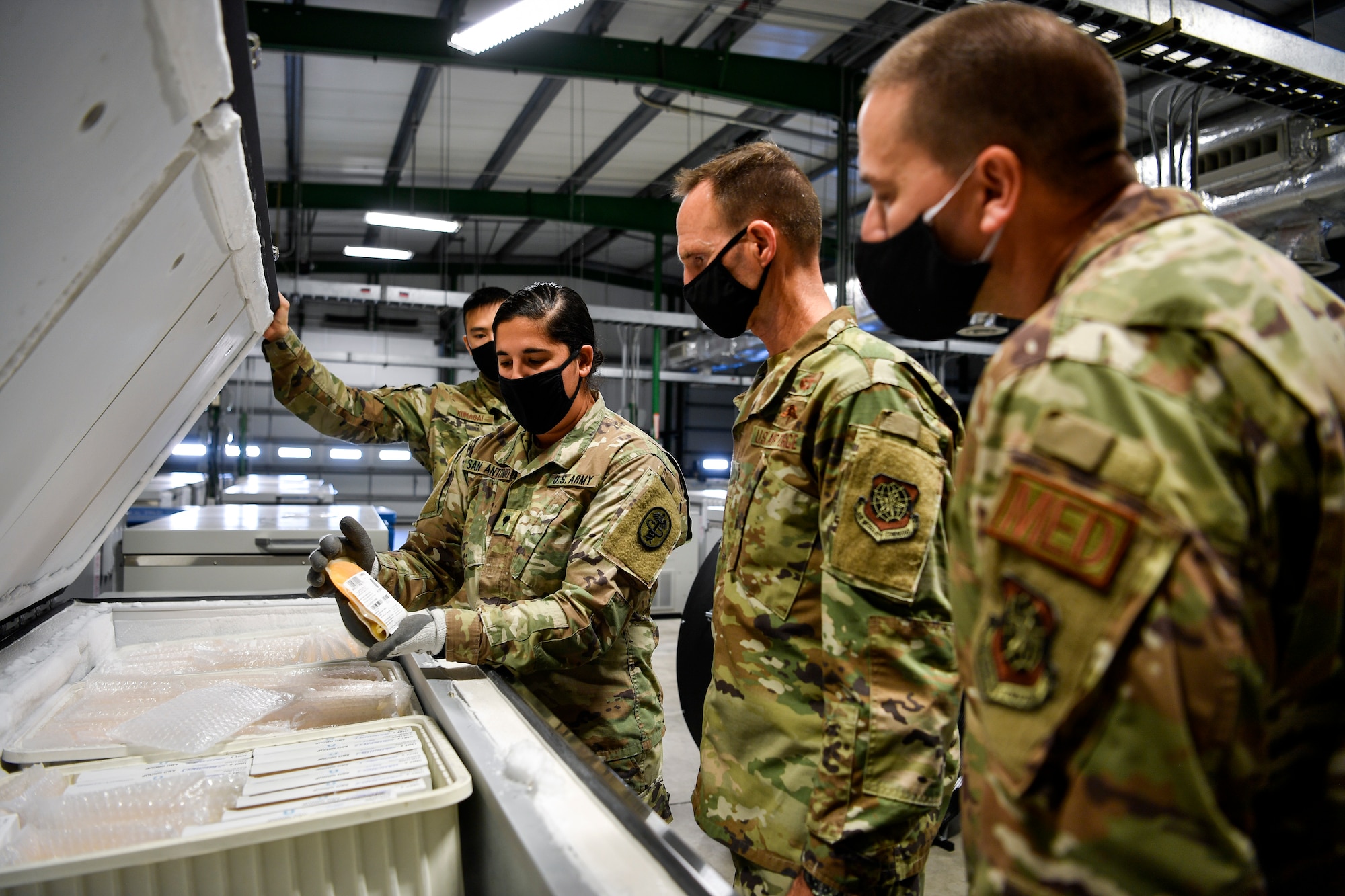 U.S. Air Force Brig. Gen. Norman West, Air Mobility Command surgeon general, and Chief Master Sgt. David Little, AMC medical enlisted force chief, look over frozen blood samples during a walk-through of the Armed Services Whole Blood Processing Laboratory – East on Joint Base McGuire-Dix-Lakehurst, N.J., Oct. 22, 2020. Serving as one of two ASWBPL, they are responsible for central receipt and confirmation of blood products from continental United States blood banks and the further shipment of those products to designated geographic Combatant Command and other Military Treatment Facilities. (U.S. Air Force photo by Staff Sgt. Jake Carter)