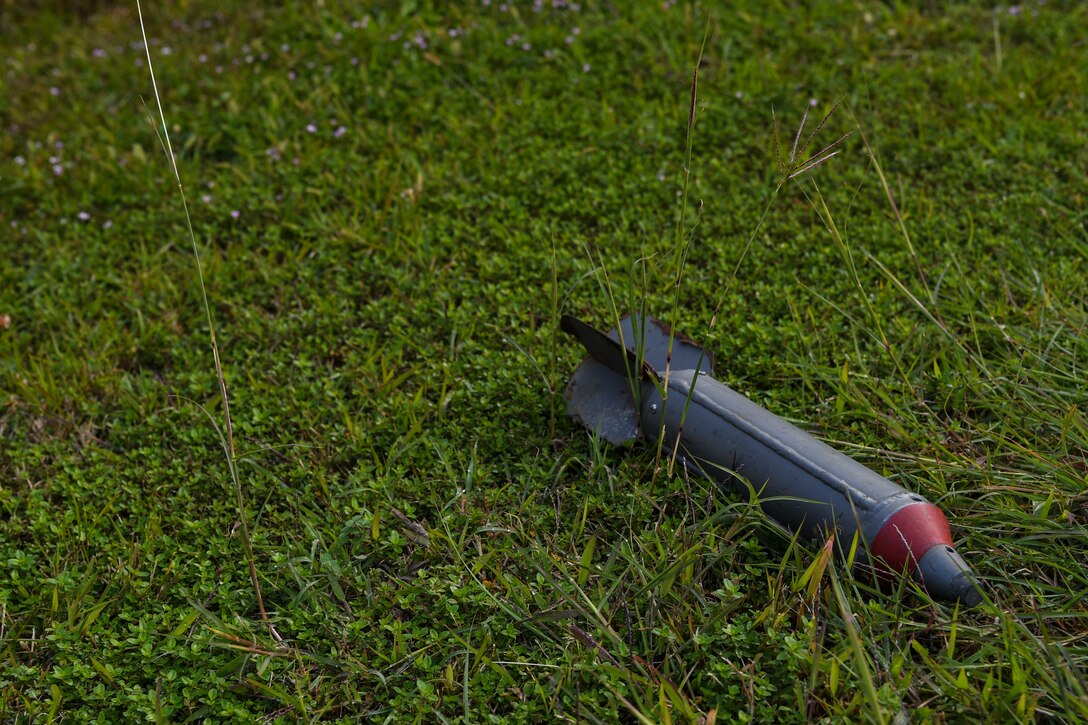 A simulated unexploded ordnance (UXO) sits in the grass during an exercise at Aviano Air Base, Italy, Oct. 20, 2020. The UXO was placed there during exercise Nodal Lightning for Personnel Accountably Report teams to find and report it. (U.S. Air Force photo by Airman 1st Class Thomas S. Keisler IV)