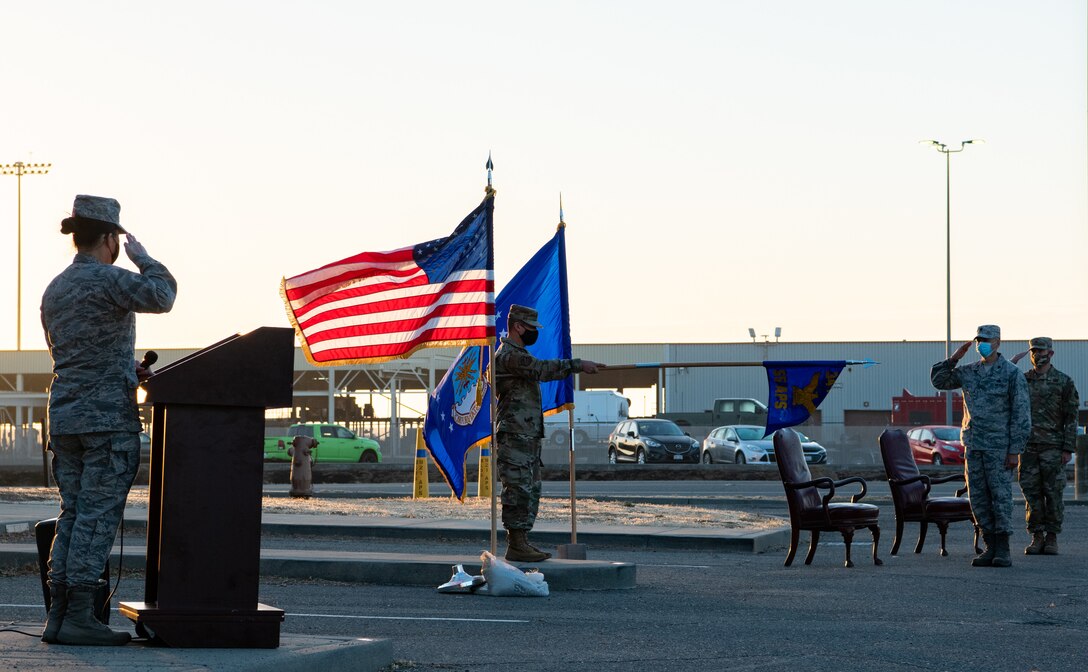 Airmen of th 55th Aerial Port Squadron salute the colors during the playing of the National Anthem during an assumption of command ceremony Oct. 24, 2020, at Travis Air Force Base, Calif. Maj. Nicholas Botich assumed command of the 55th APS.