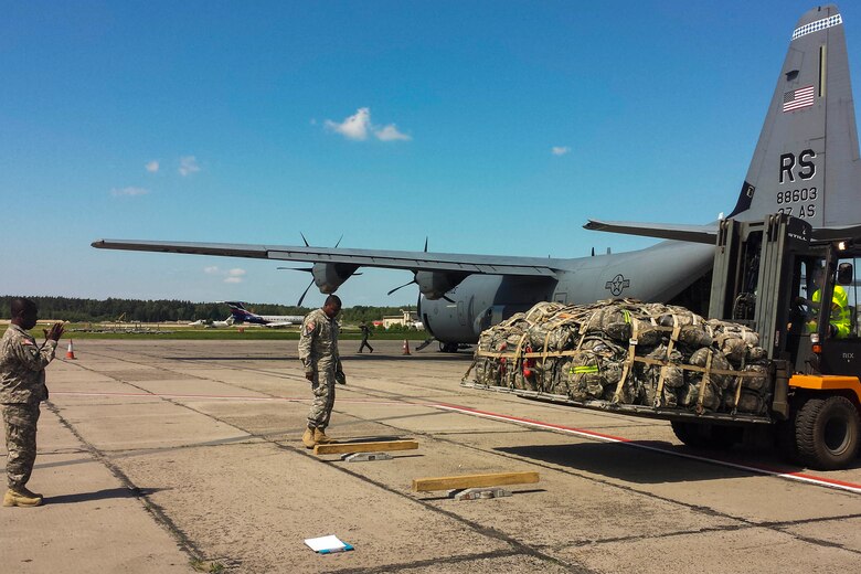 A forklift sits near an aircraft on a runway.