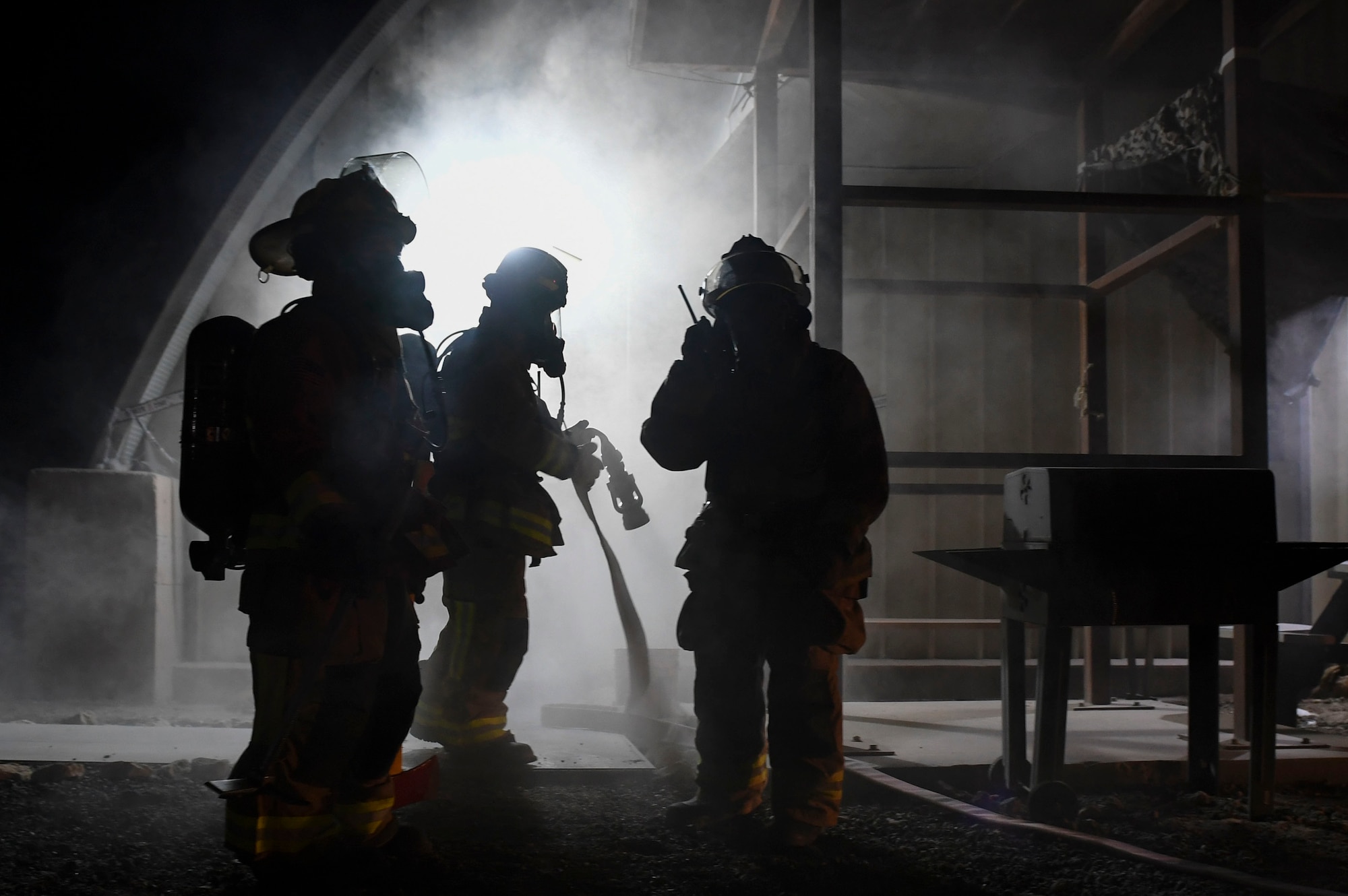 Firefighters assigned to the 386th Expeditionary Civil Engineer Squadron prepare to enter a smoke-filled building during the Air and Missile Defense Exercise 21-1 at Ali Al Salem Air Base, Kuwait, Oct. 22, 2020.