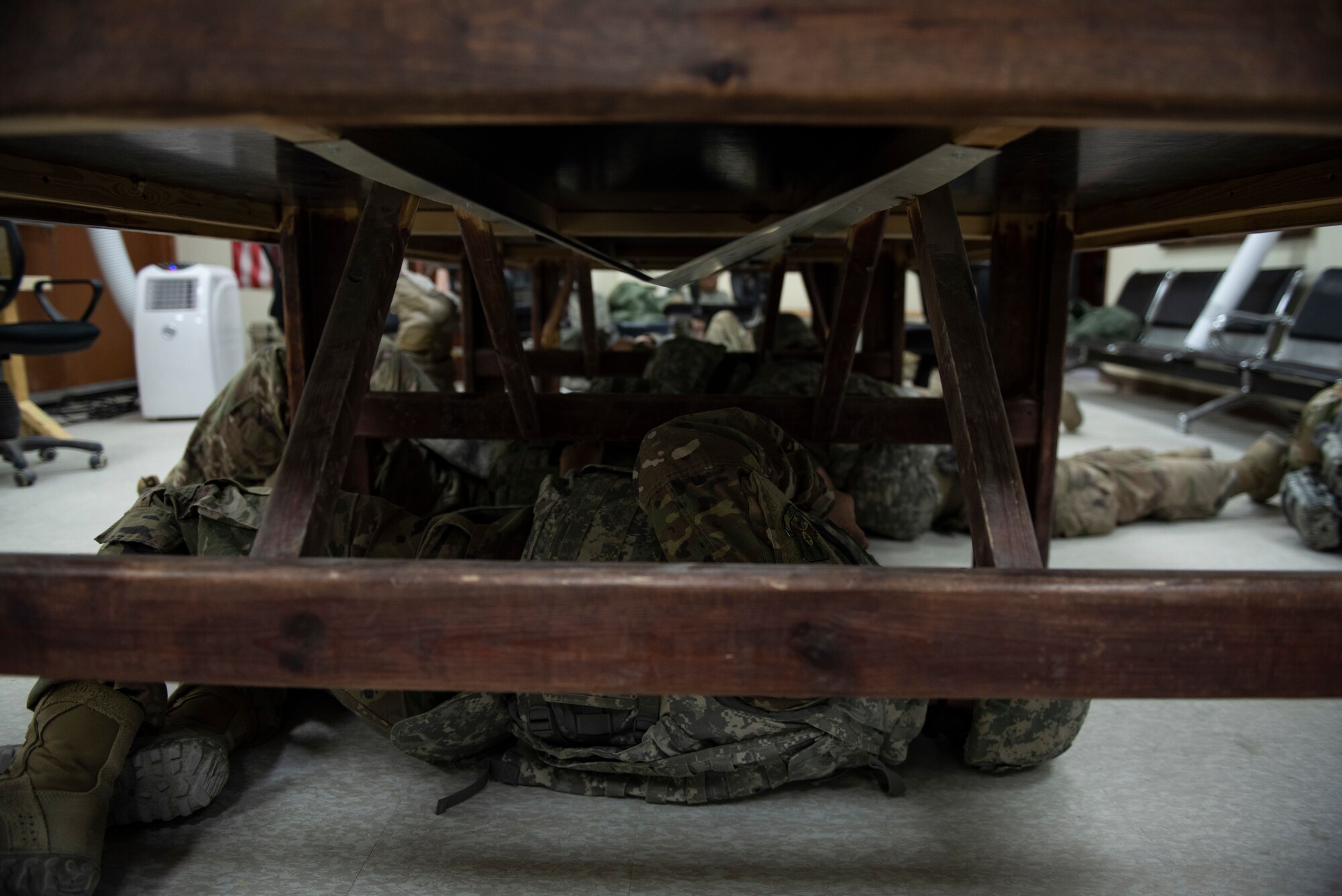 U.S. Air Force Airmen from the 386th Expeditionary Civil Engineer Squadron take cover during the Air and Missile Defense Exercise 21-1 at Ali Al Salem Air Base, Kuwait, Oct. 22, 2020.