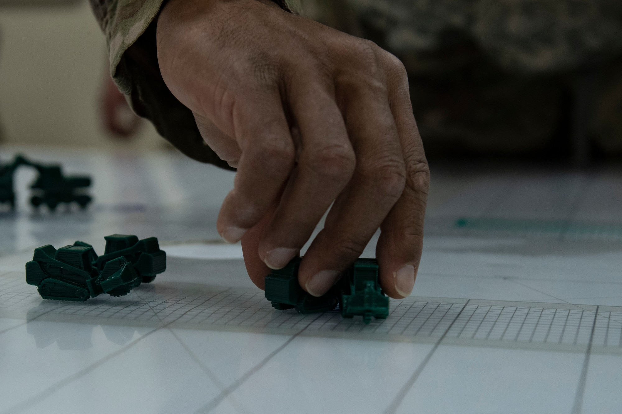 A U.S. Air Force Airman assigned to the 386th Expeditionary Civil Engineer Squadron moves tabletop pieces during the Air and Missile Defense Exercise 21-1 at Ali Al Salem Air Base, Kuwait, Oct. 22, 2020.