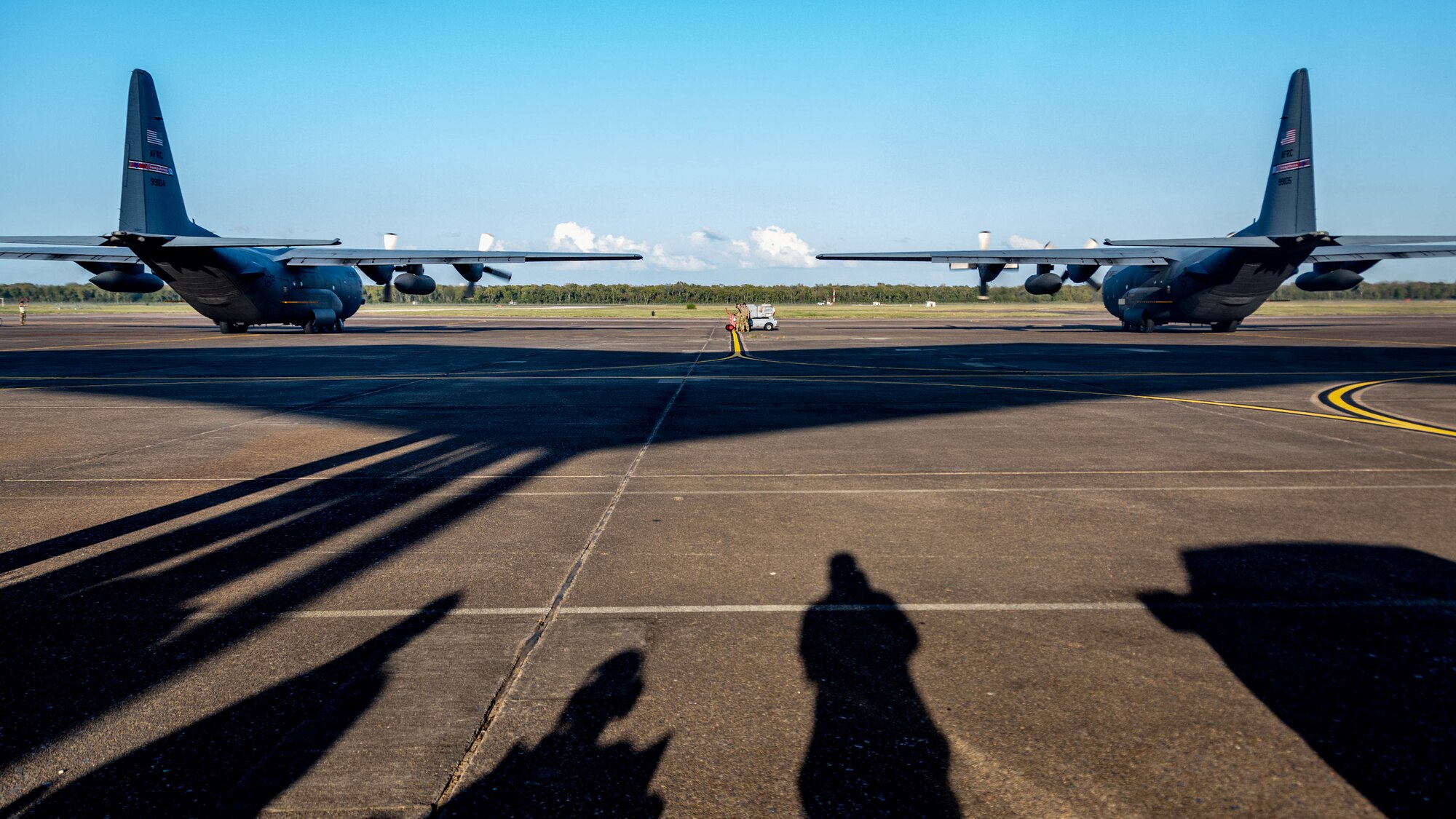 A pair of U.S. Air Force Reserve C-130H Hercules aircraft assigned to the 910th Airlift Wing, based at Youngstown Air Reserve Station, Ohio and equipped with a Modular Aerial Spray System, starts engines prior to taking off while ground support personnel look on at Barksdale Air Force Base, Louisiana, Oct. 22, 2020.