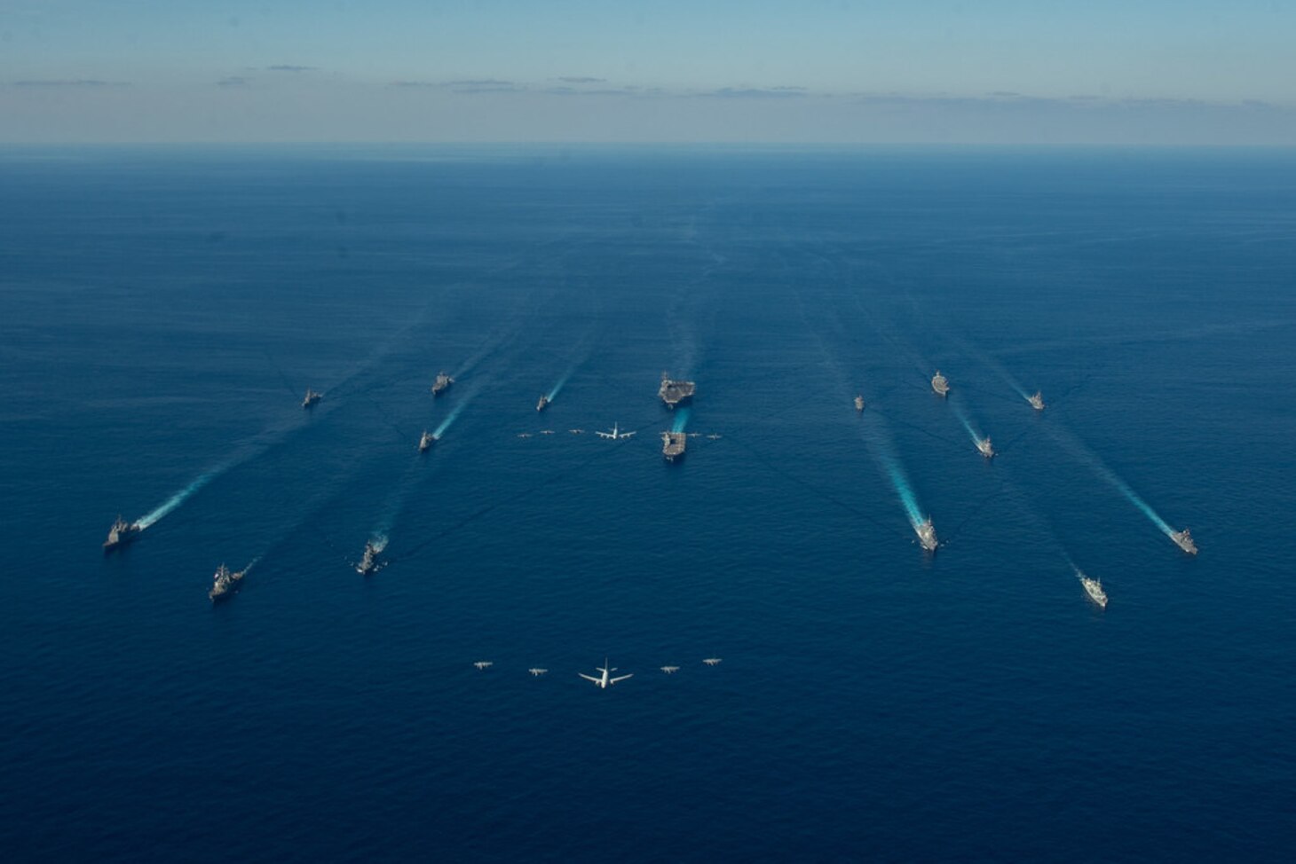 U.S. Navy ships assigned to the Ronald Reagan Carrier Strike Group join ships of Japan Maritime Self-Defense Force (JMSDF) Escort Flotilla 1, Escort Flotilla 4, and the Royal Canadian Navy in formation while aircraft from the U.S. Navy, U.S. Marine Corps, U.S. Air Force, JMSDF and Japan Air Self-Defense Force fly overhead during exercise Keen Sword, Oct. 26.