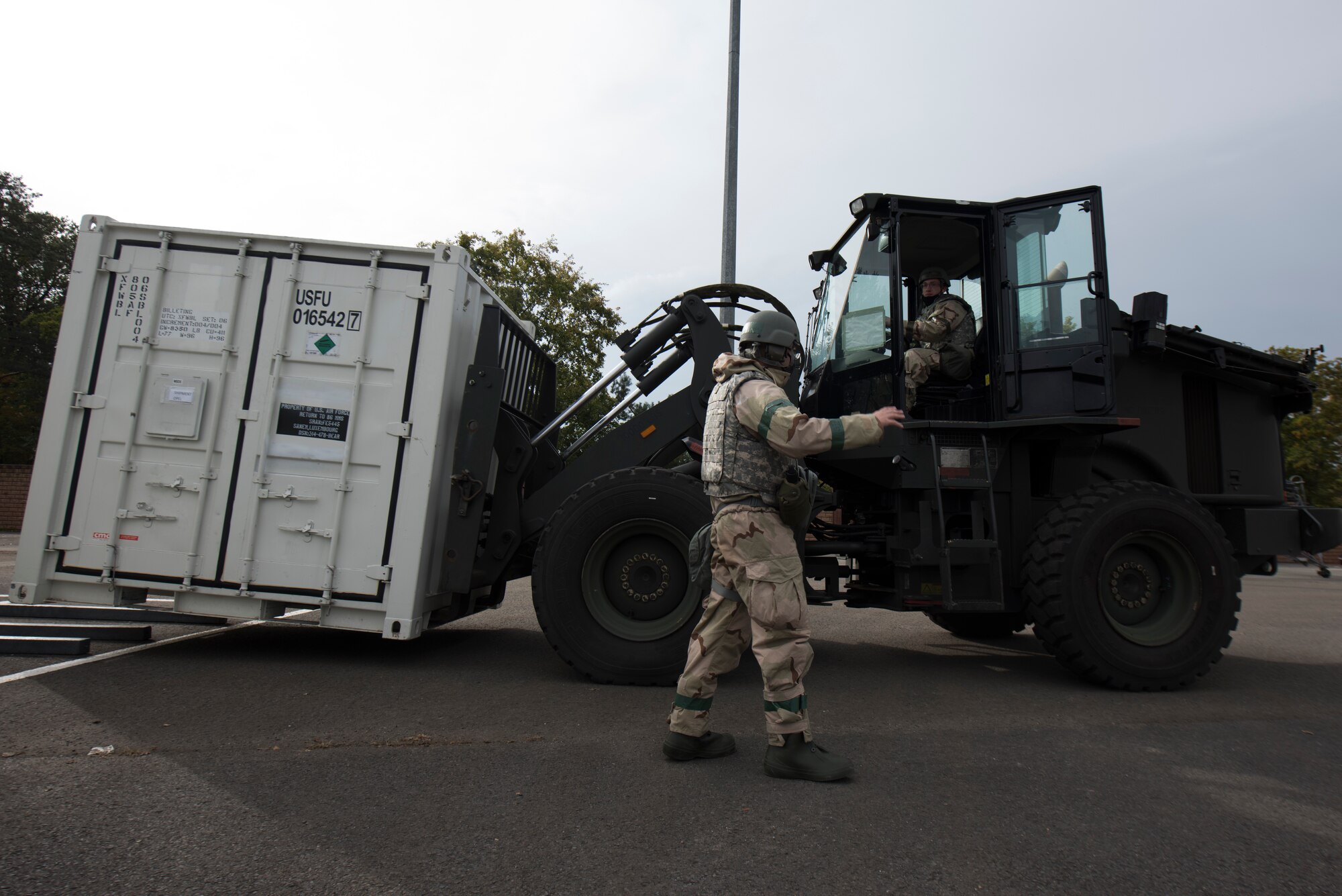 An Airman directs another Airman to a delivery truck.