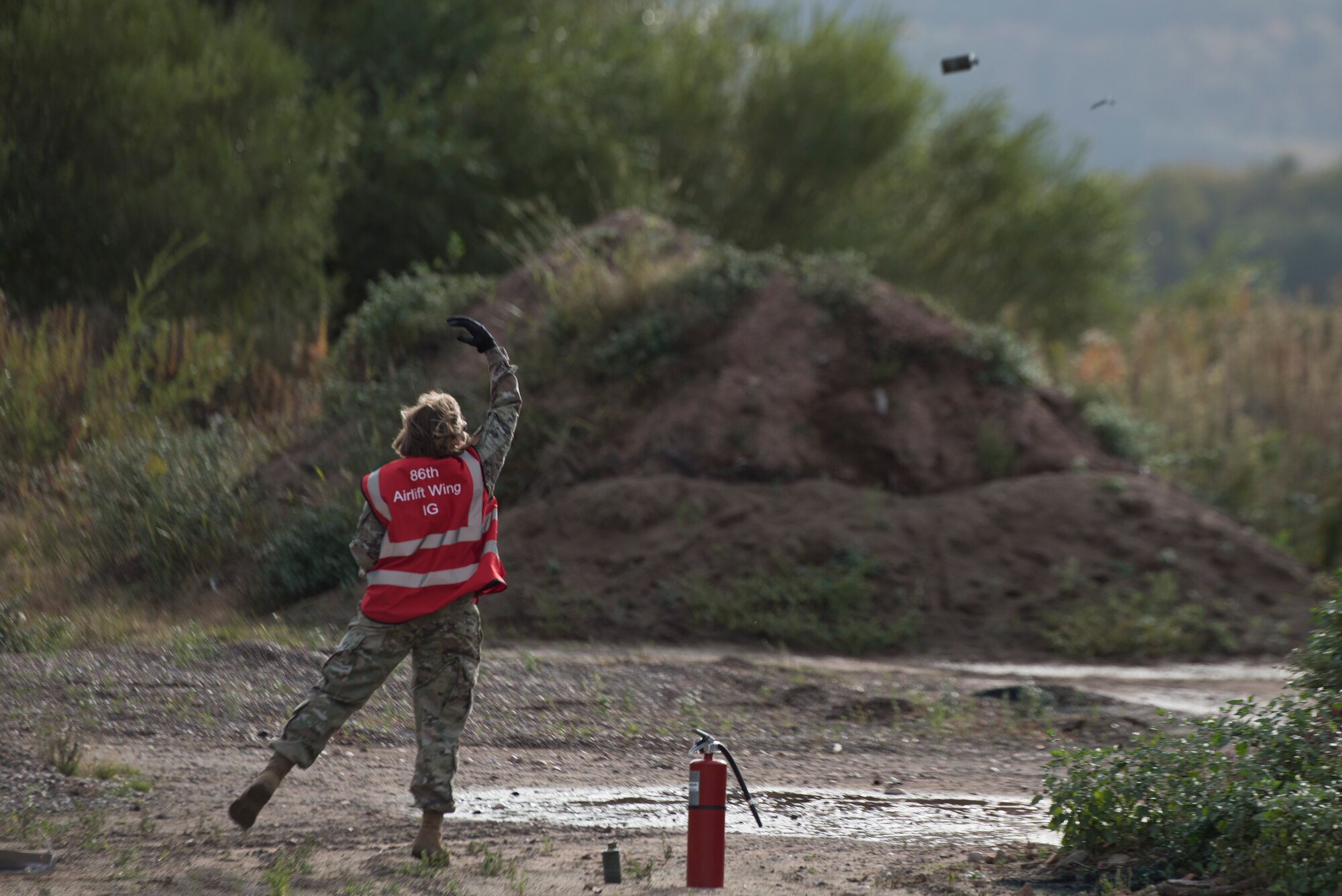 An Airman throws a smoke grenade.