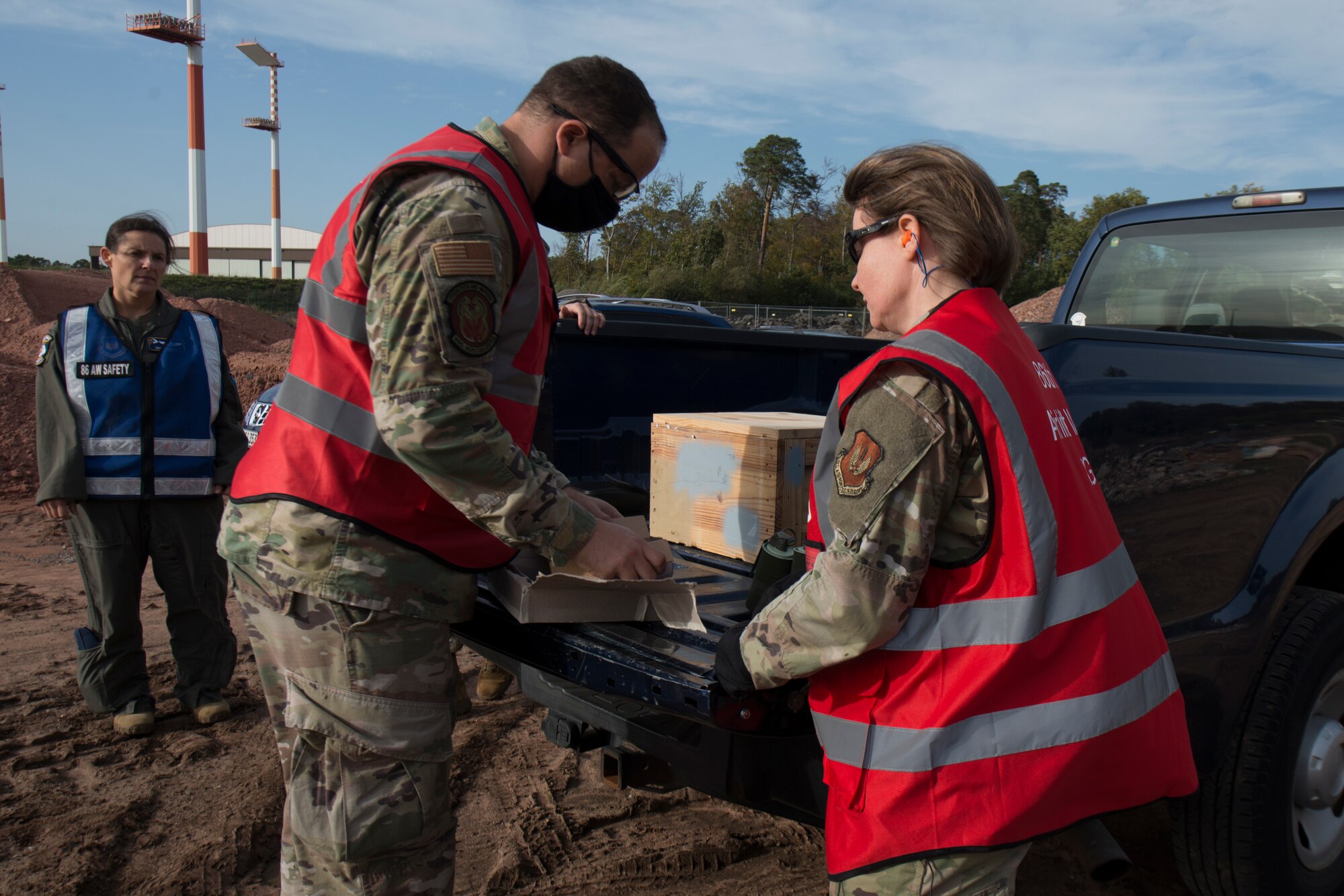 An Airman gives smoke grenades and ground burst materials to another Airman.