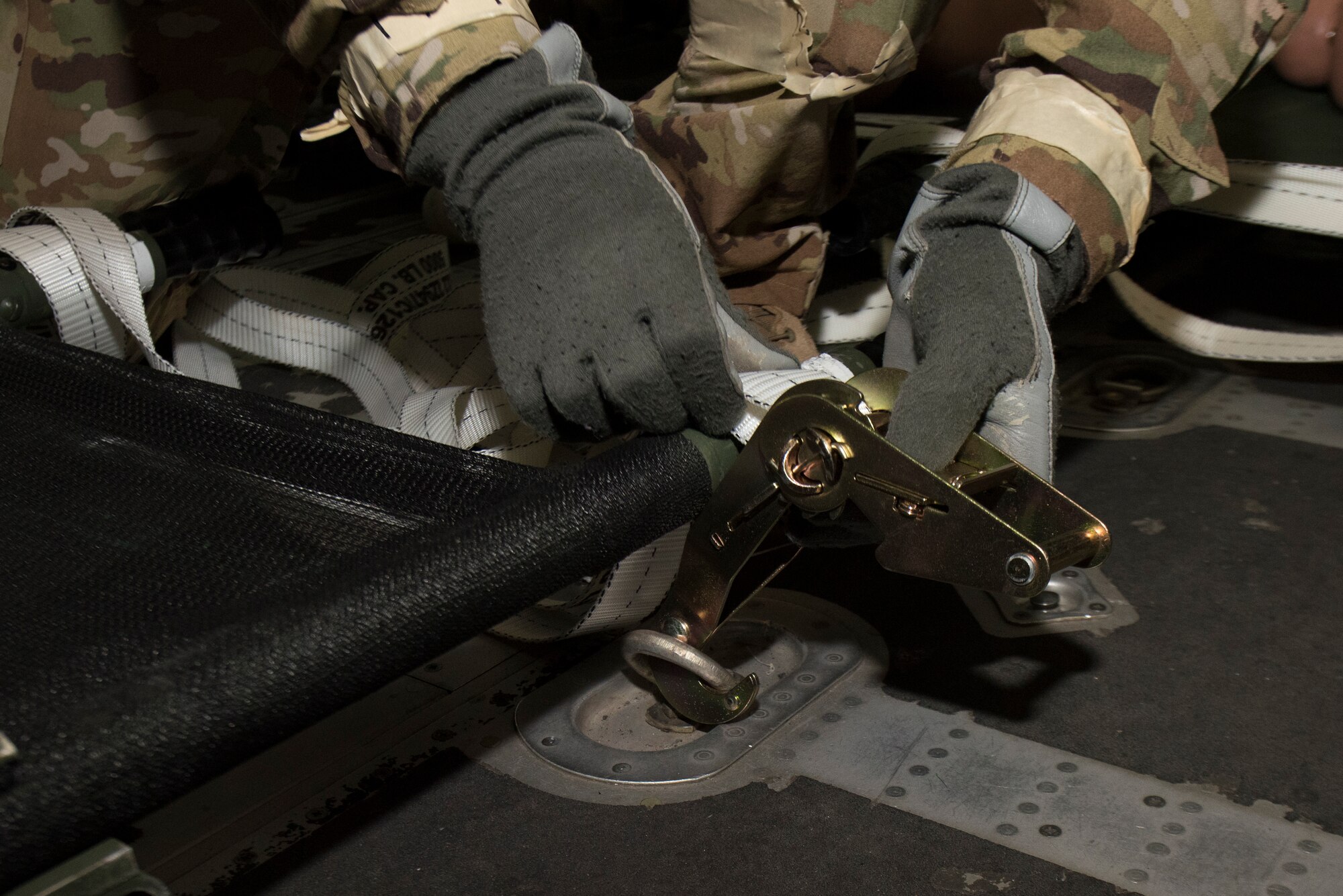 An Airmen secures a cot to a C-130J Hercules.