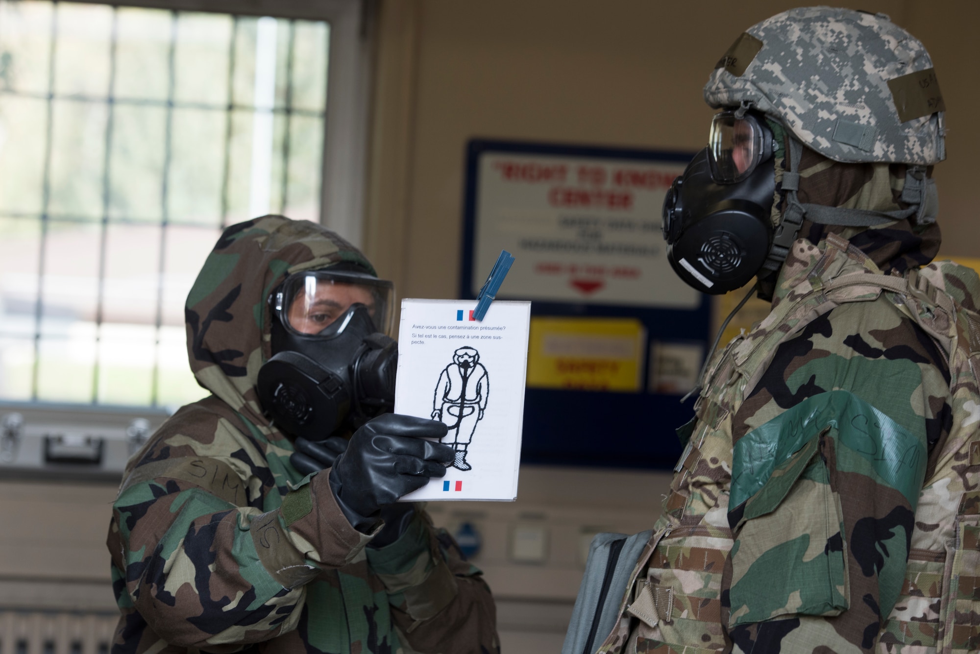 An Airmen briefs another Airmen on decontamination procedures.