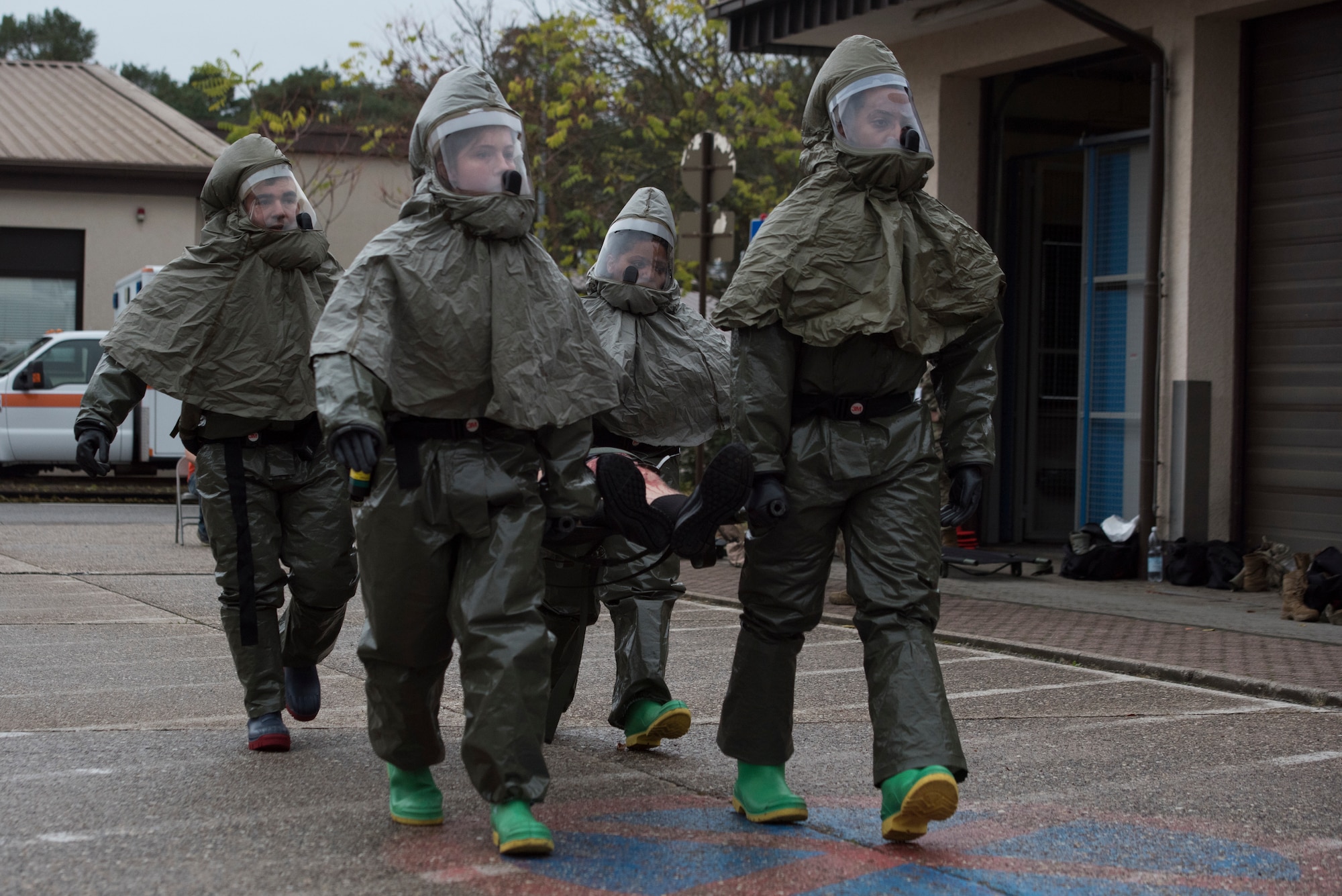 Medical Airmen transport a simulated victim to a decontamination tent.