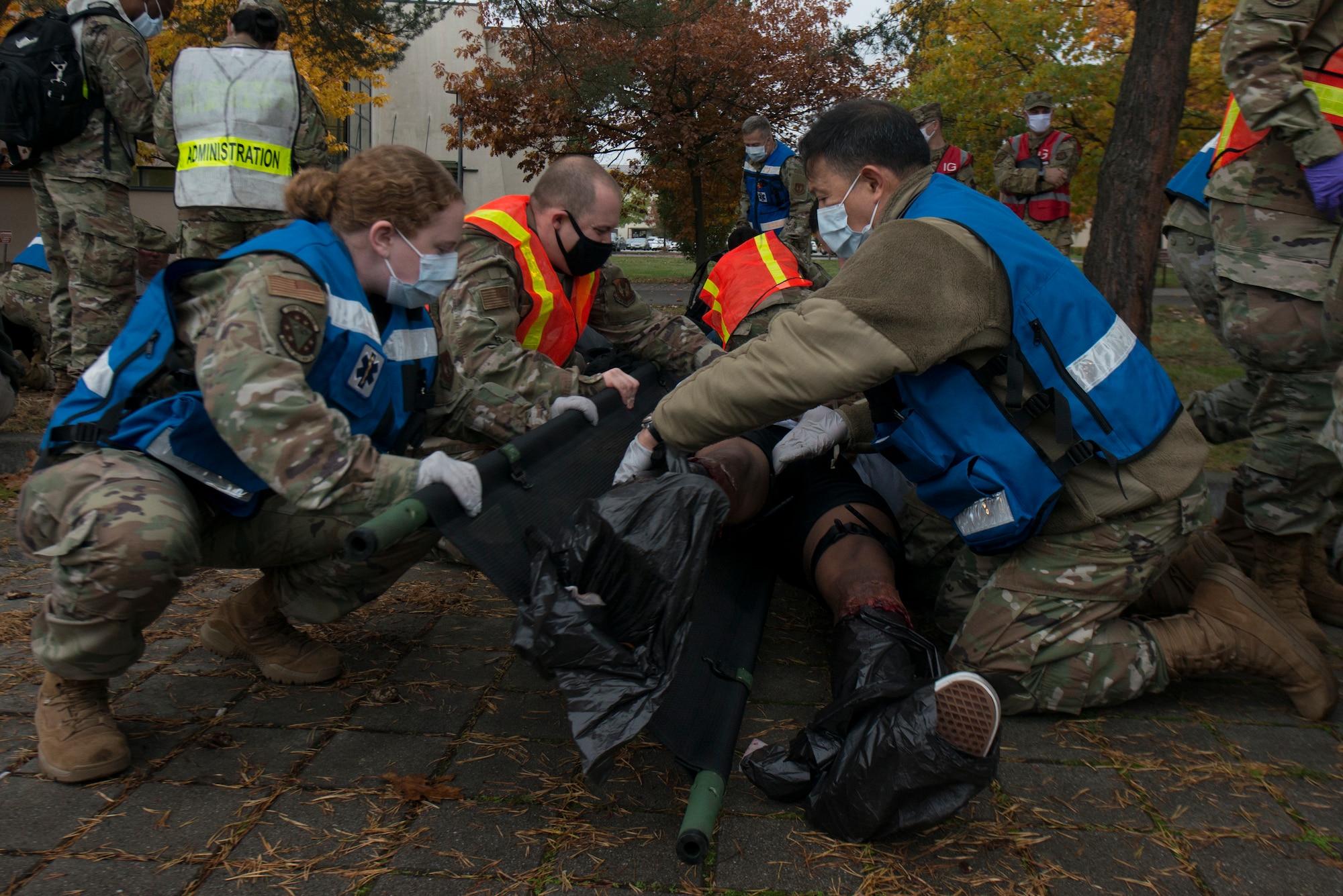 Medical Airmen transfer a simulated victim to a stretcher.